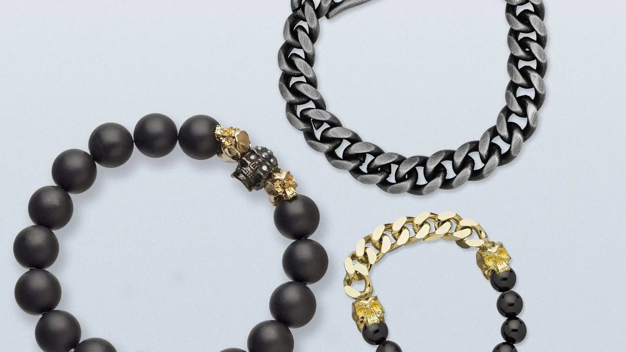 Men’s Bracelets collection featuring a silver-toned chain, black beaded skull, and gold accents