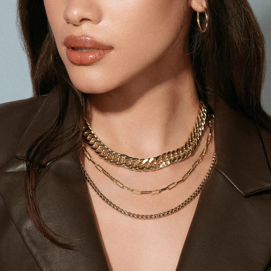 Woman wearing layered gold necklace set and dark brown leather jacket in Necklaces collection