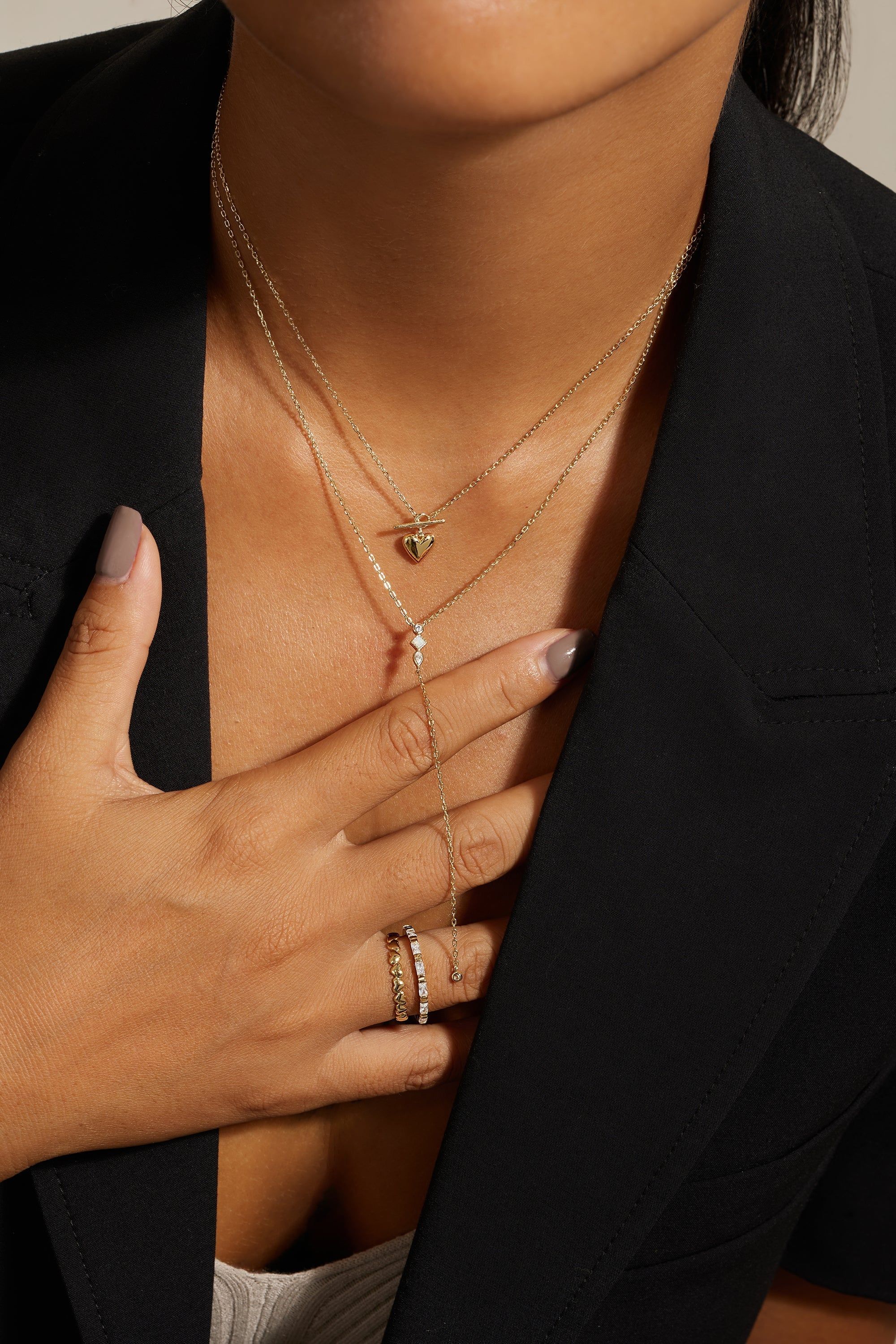 Layered gold necklaces and rings featuring the CZ & Opal Thin Chain Lariat jewelry