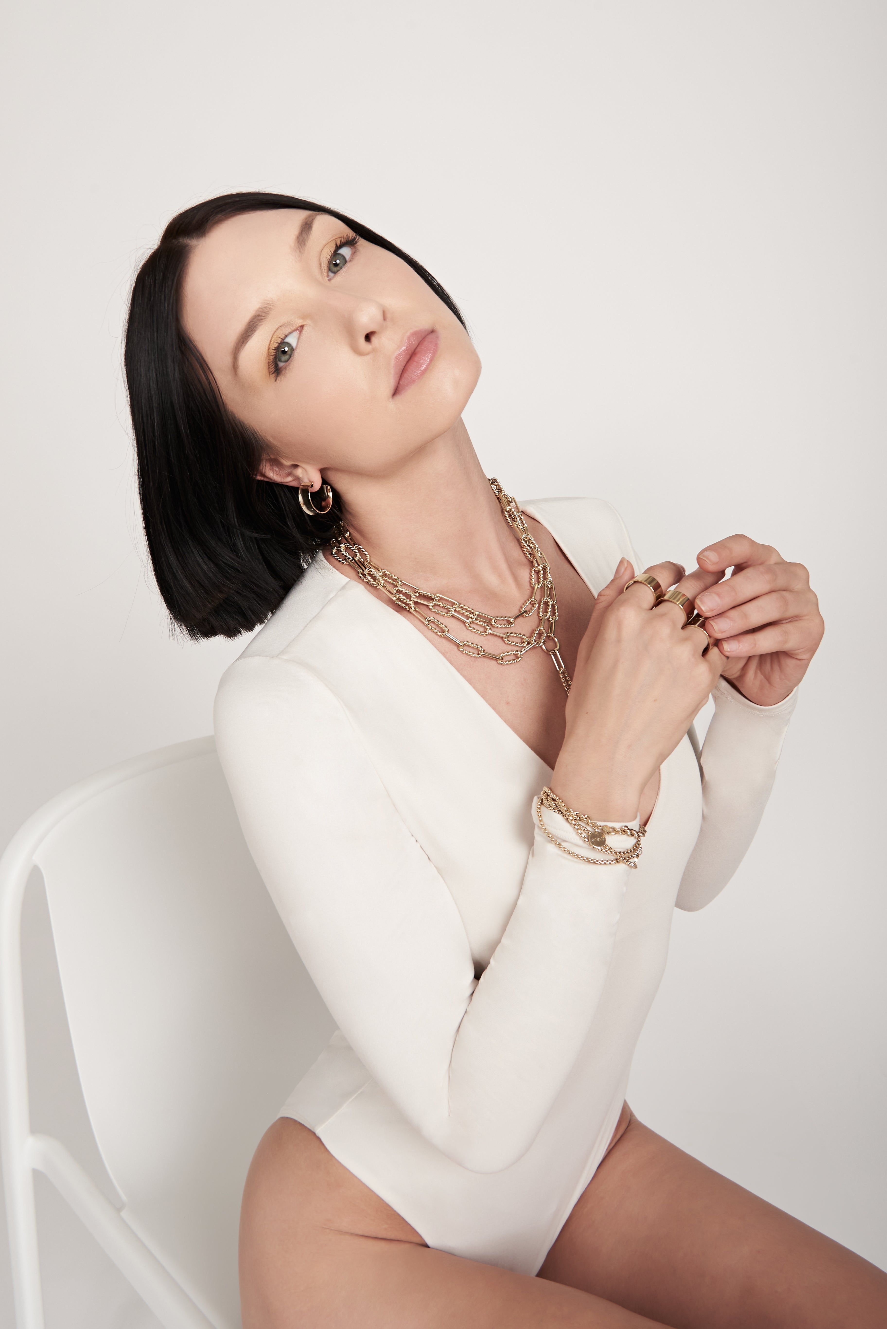 Woman wearing gold jewelry with Enzo Necklace showcasing elegant style