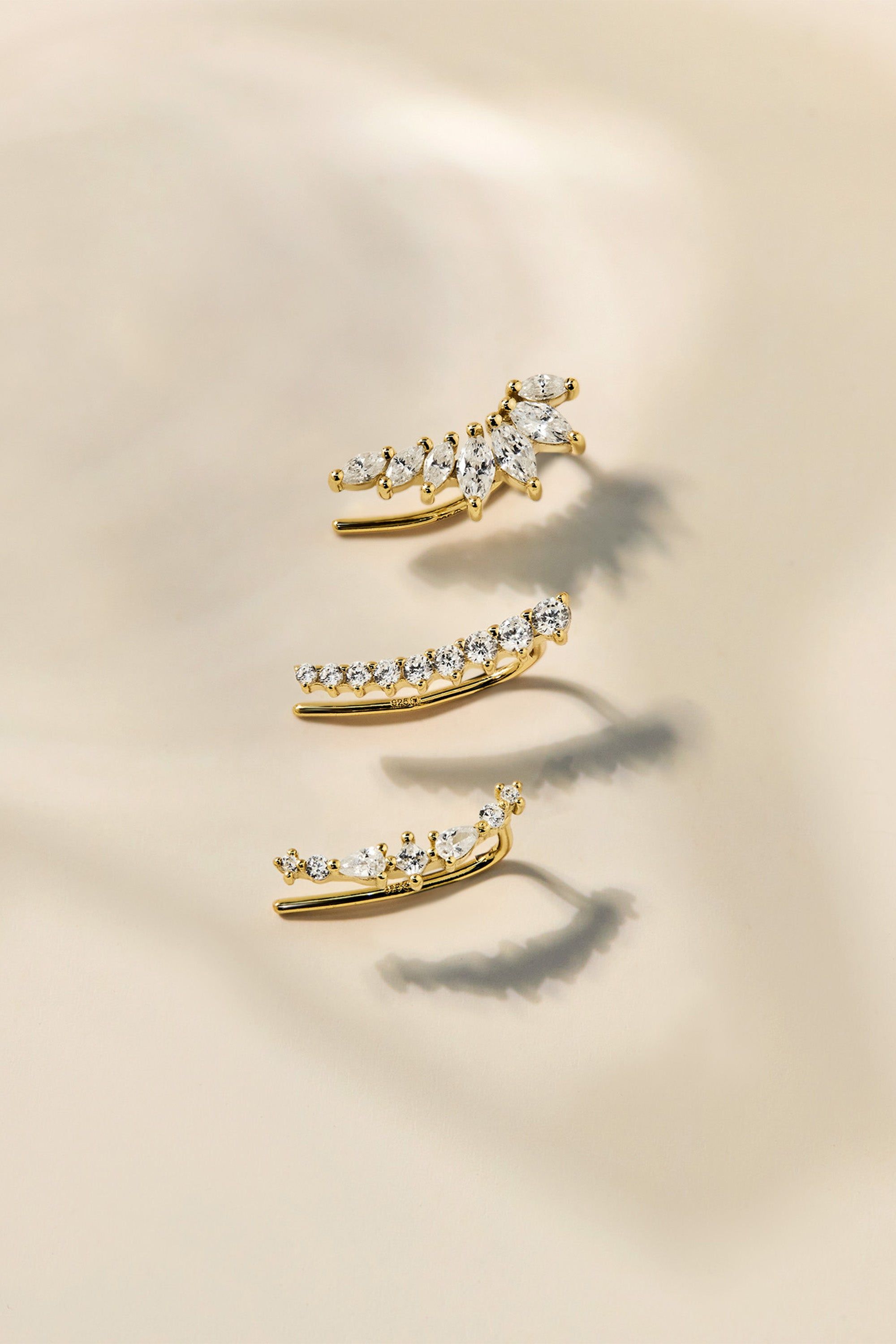 Three gold ear climbers with clear gemstones from Graduated Marquis Shaped CZ Ear Crawl collection