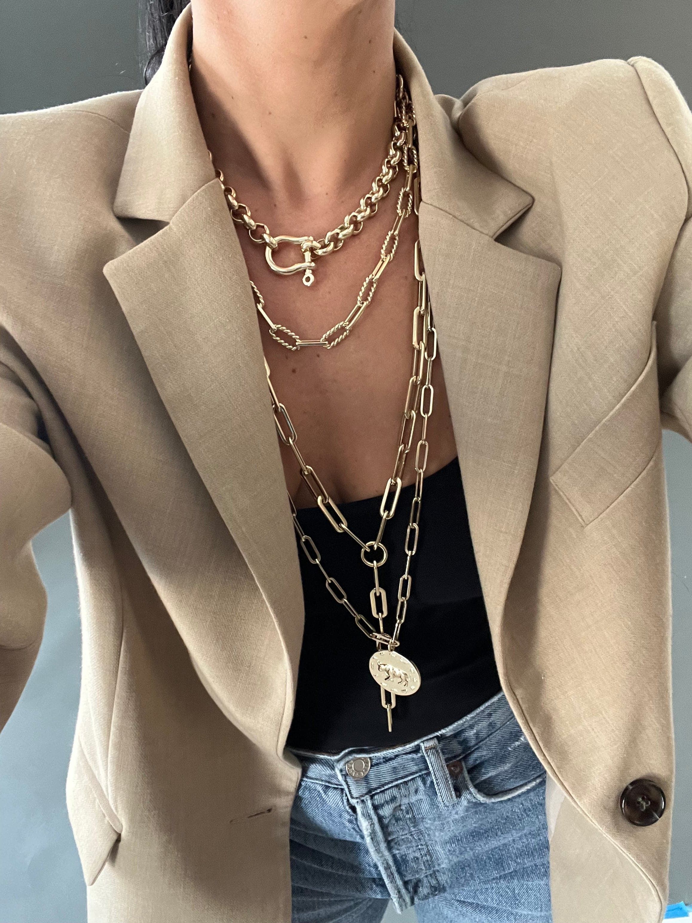 Layered gold necklaces featuring the Gisele XL Paper Clip Chain Lariat