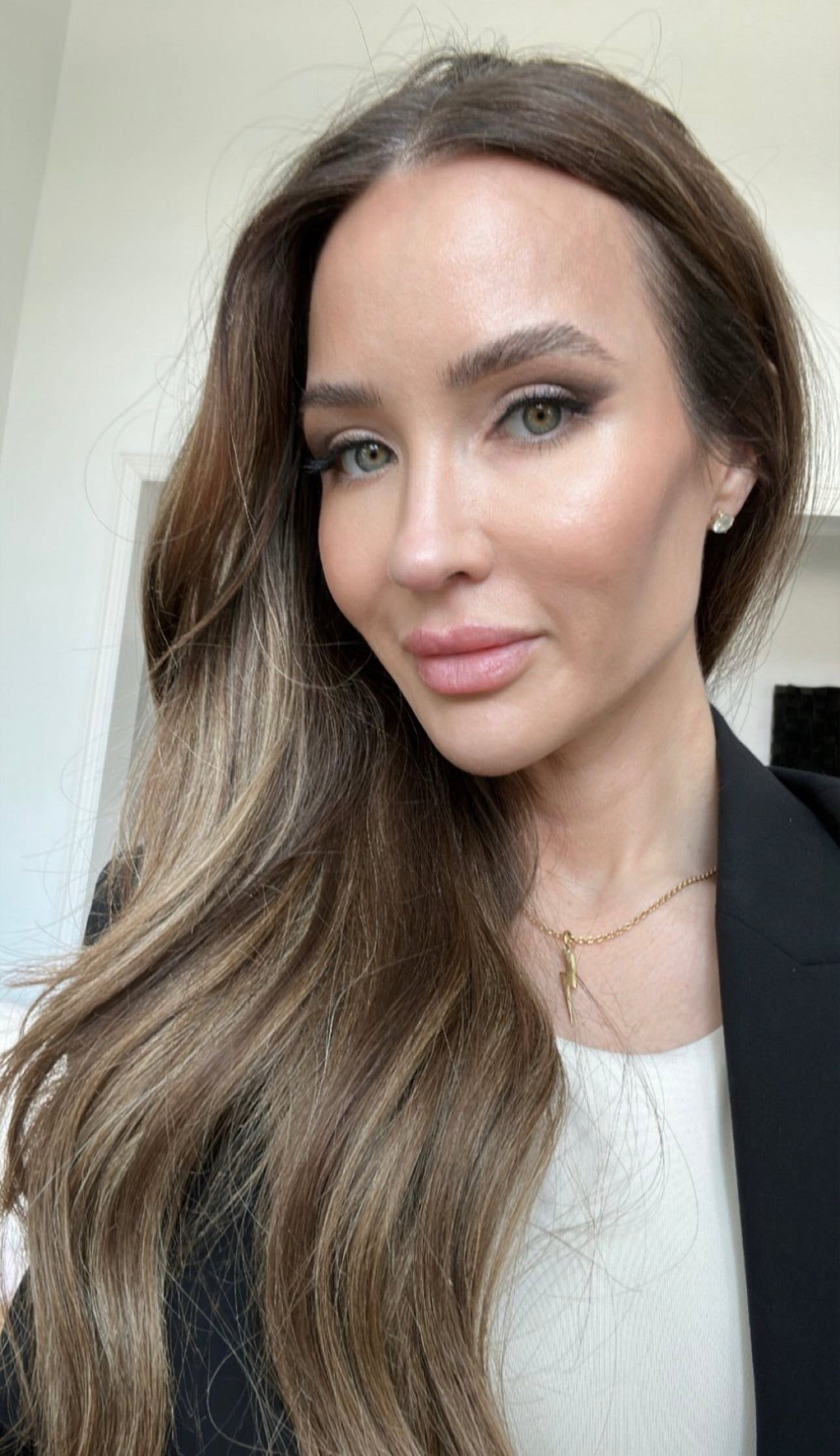 Woman with long wavy light brown hair wearing a black blazer and Katie Necklace