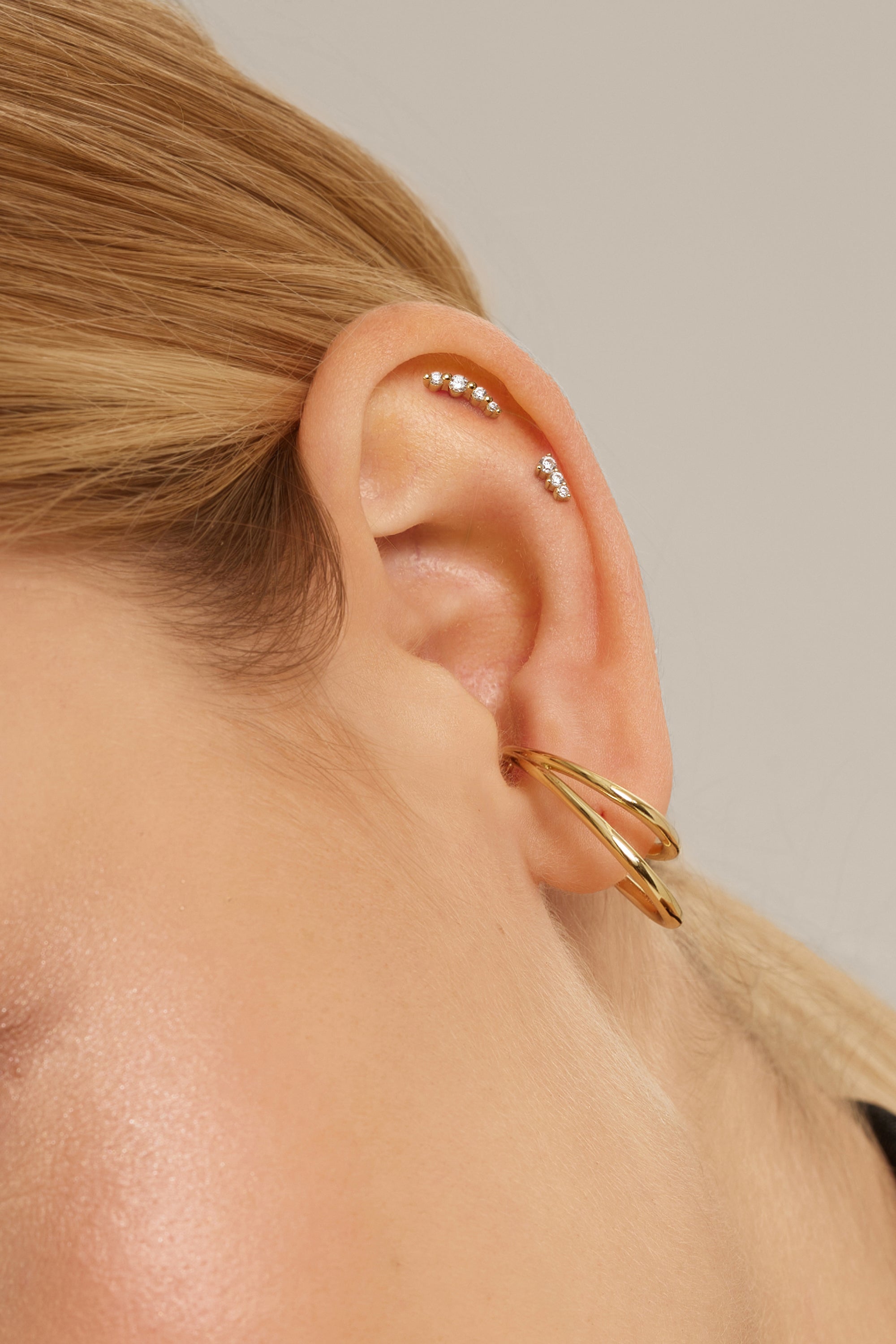 Ear with multiple gold-colored piercings showcasing the Large Dual Ear Cuff accessory