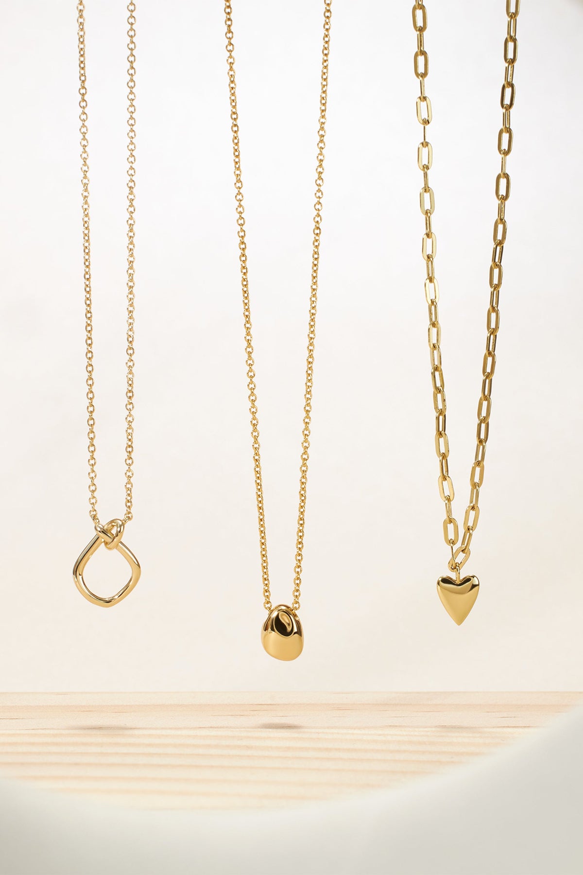 Three gold necklaces from the Micro Harmony Pebble Pendant Necklace collection