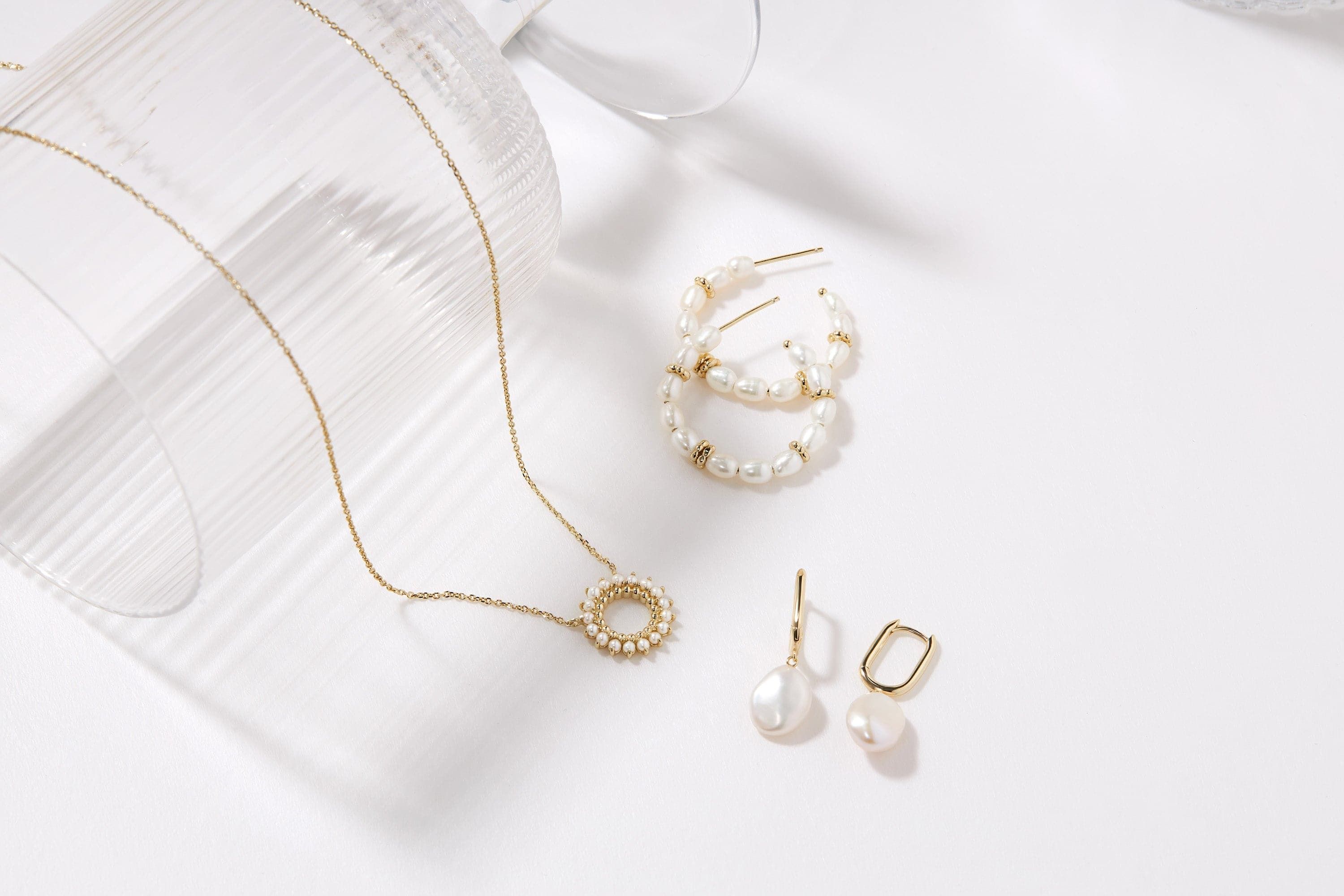 Gold necklace and pearl earrings from Pearl Beaded Huggie Hoops collection
