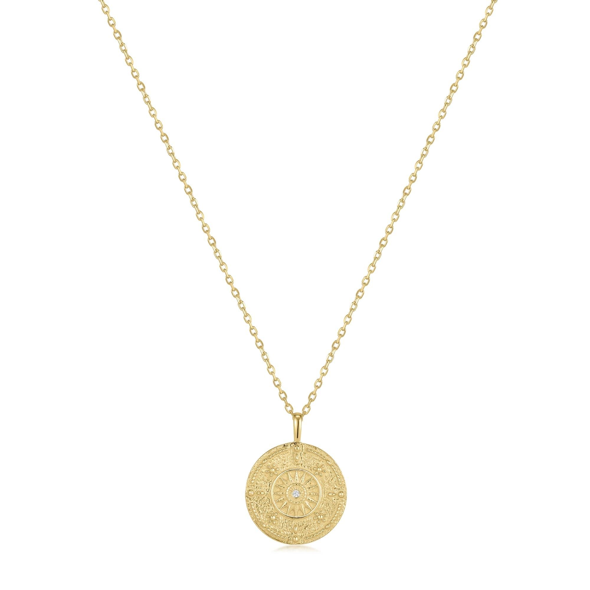 Gold chain necklace with round engraved medallion pendant featuring CZ center stone