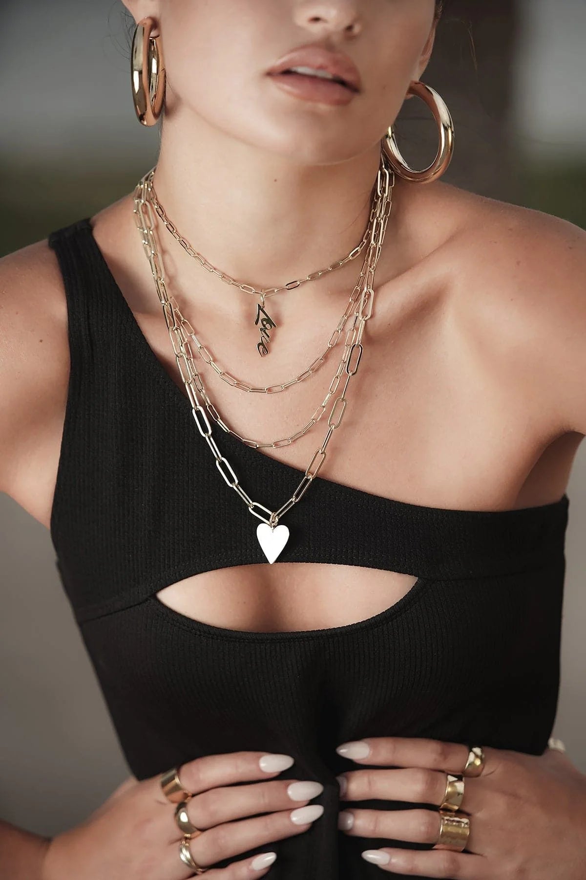 Woman wearing a stylish 14k gold chain with elongated links and recycled brass plating