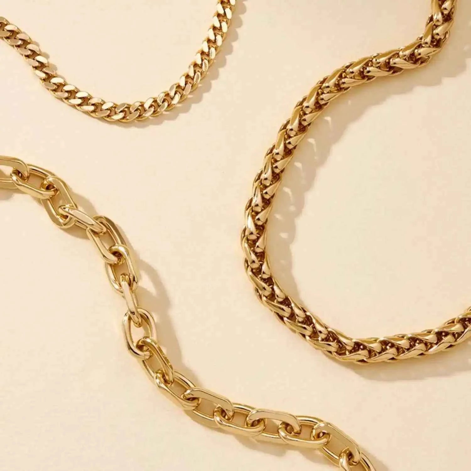 Two gold chains on a beige background