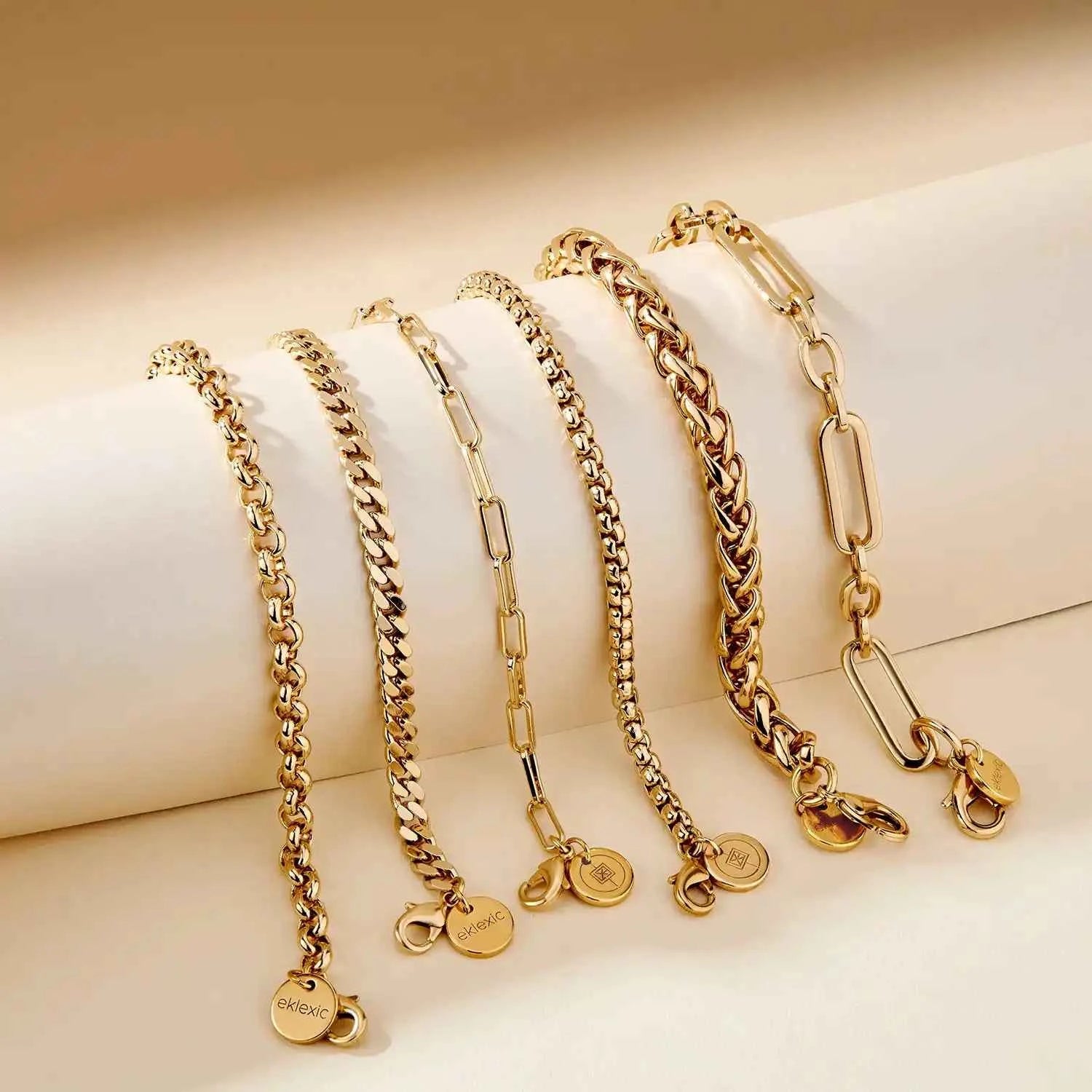 Set of gold chain necklaces on a beige background