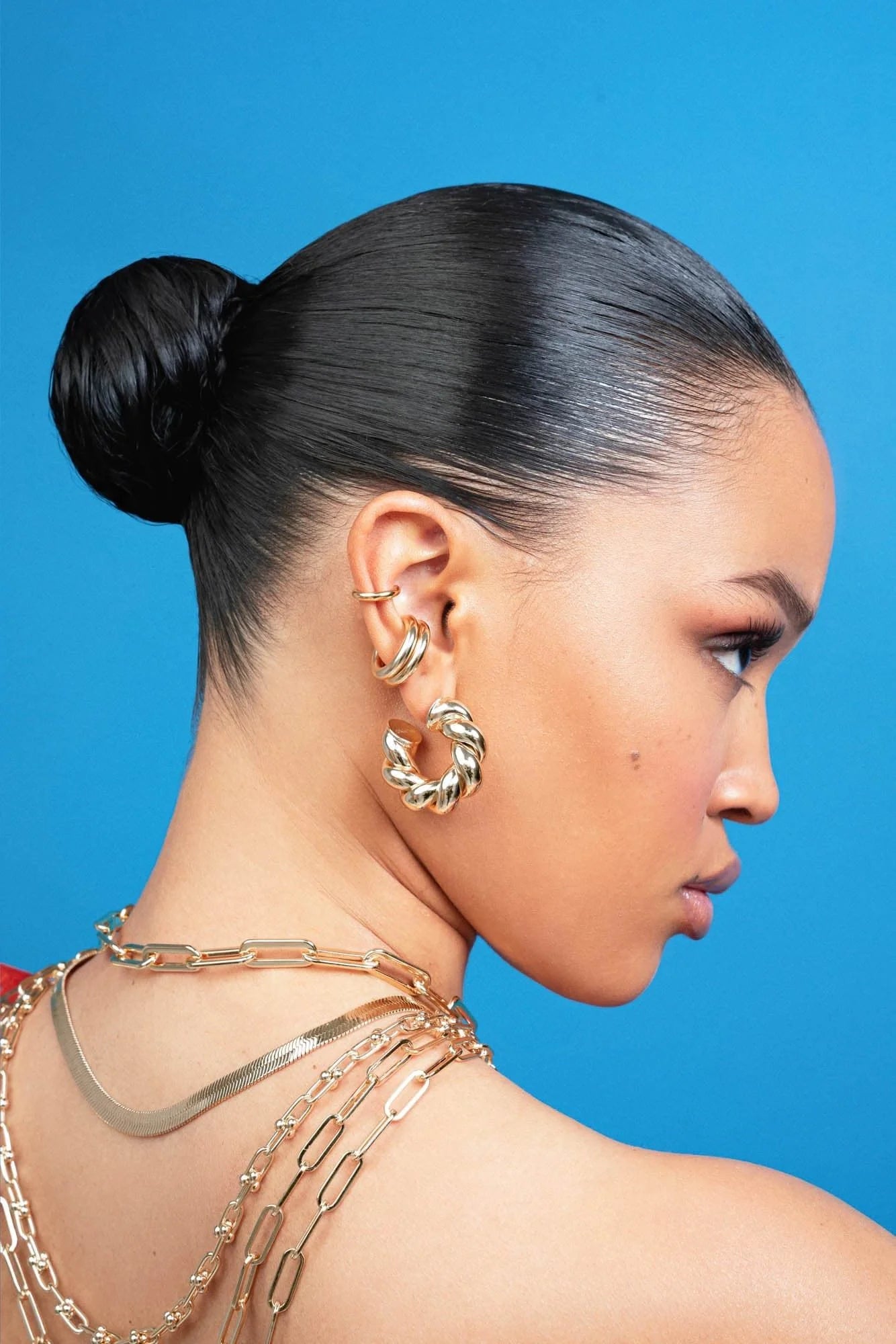 Woman with sleek bun hairstyle wearing Tallulah Hoops in recycled brass with rhodium-silver measurements