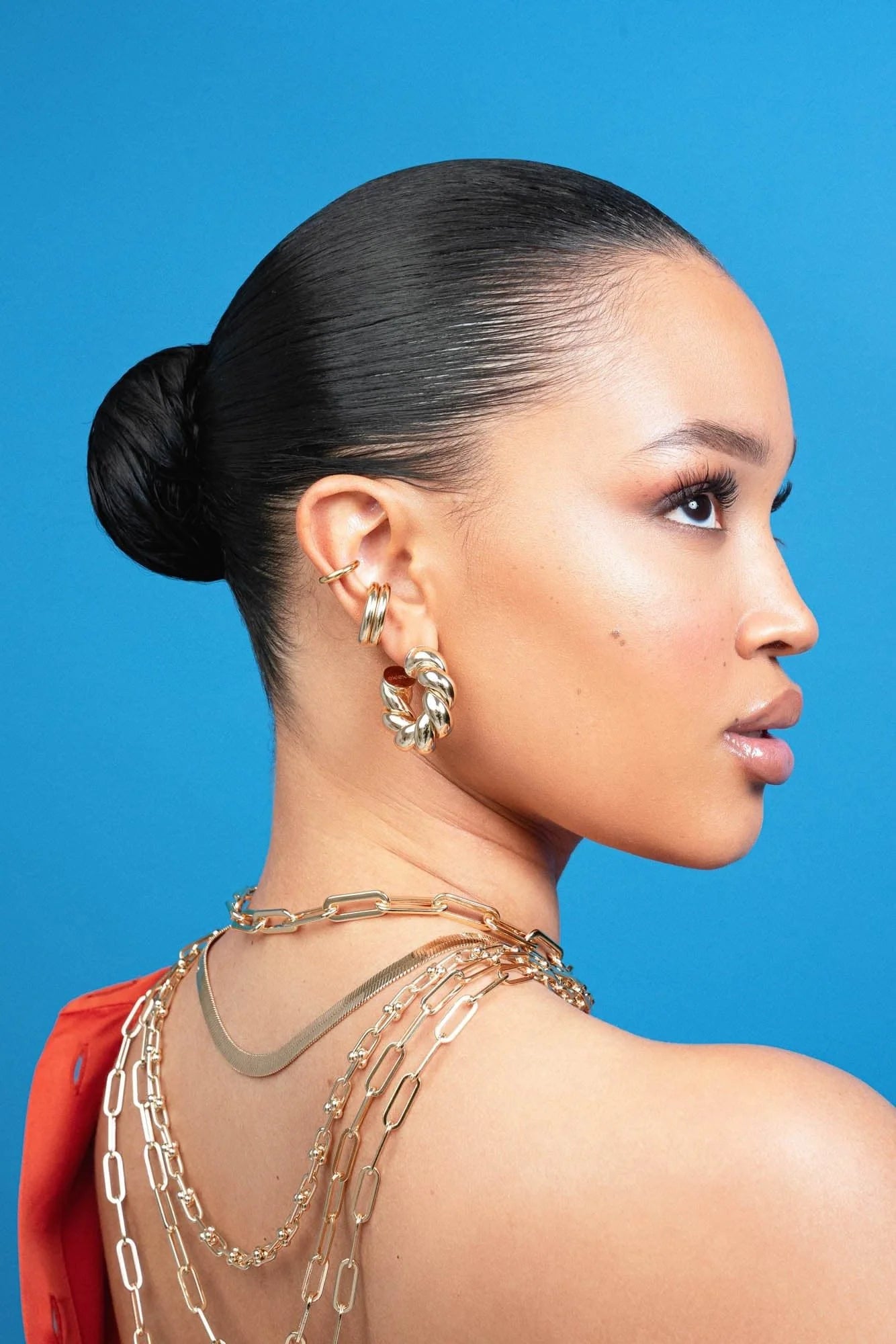 Woman with slicked-back hair wearing Tallulah Hoops in recycled brass with rhodium-silver measurements