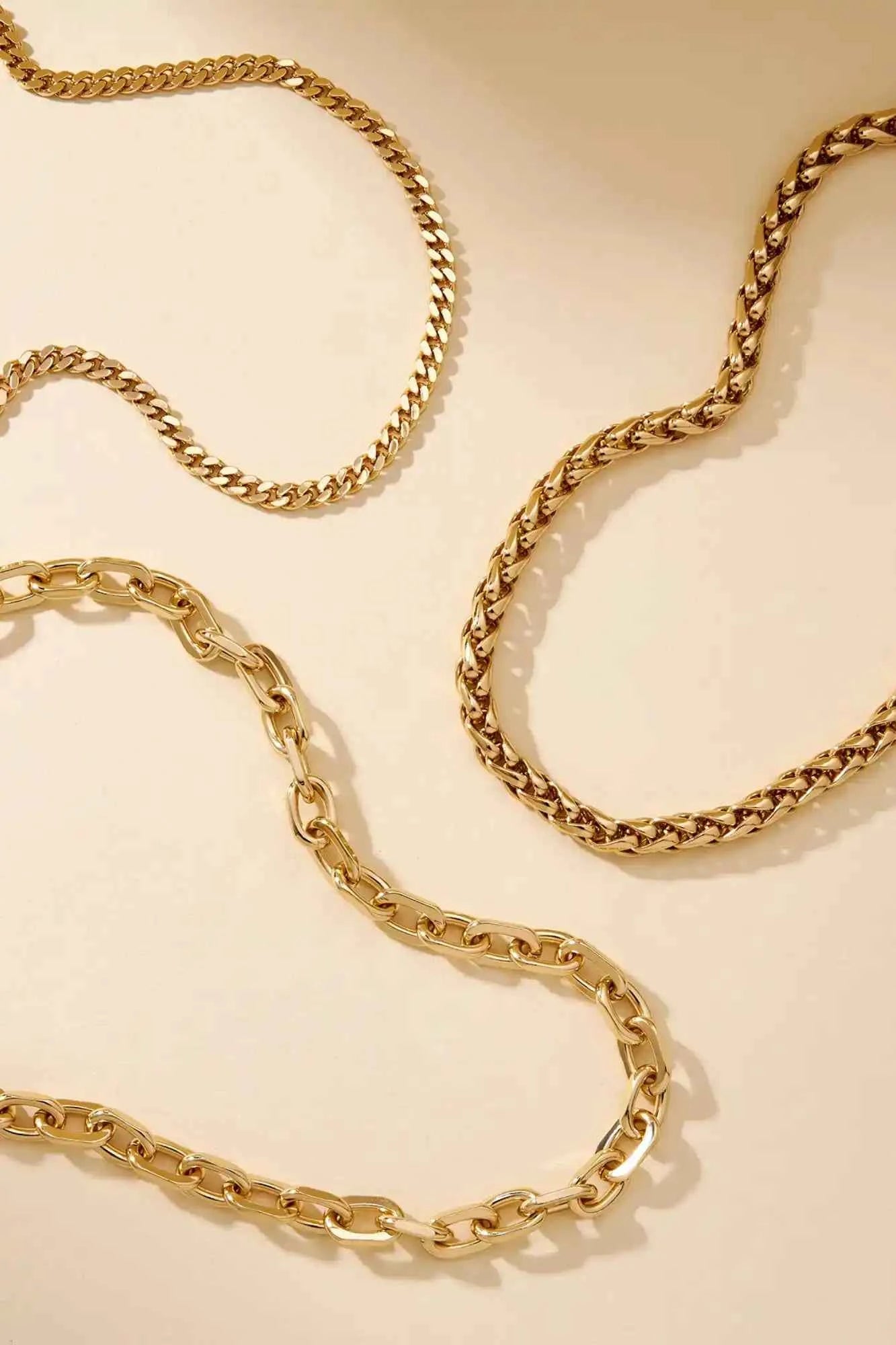 Gold chain necklace on a beige background