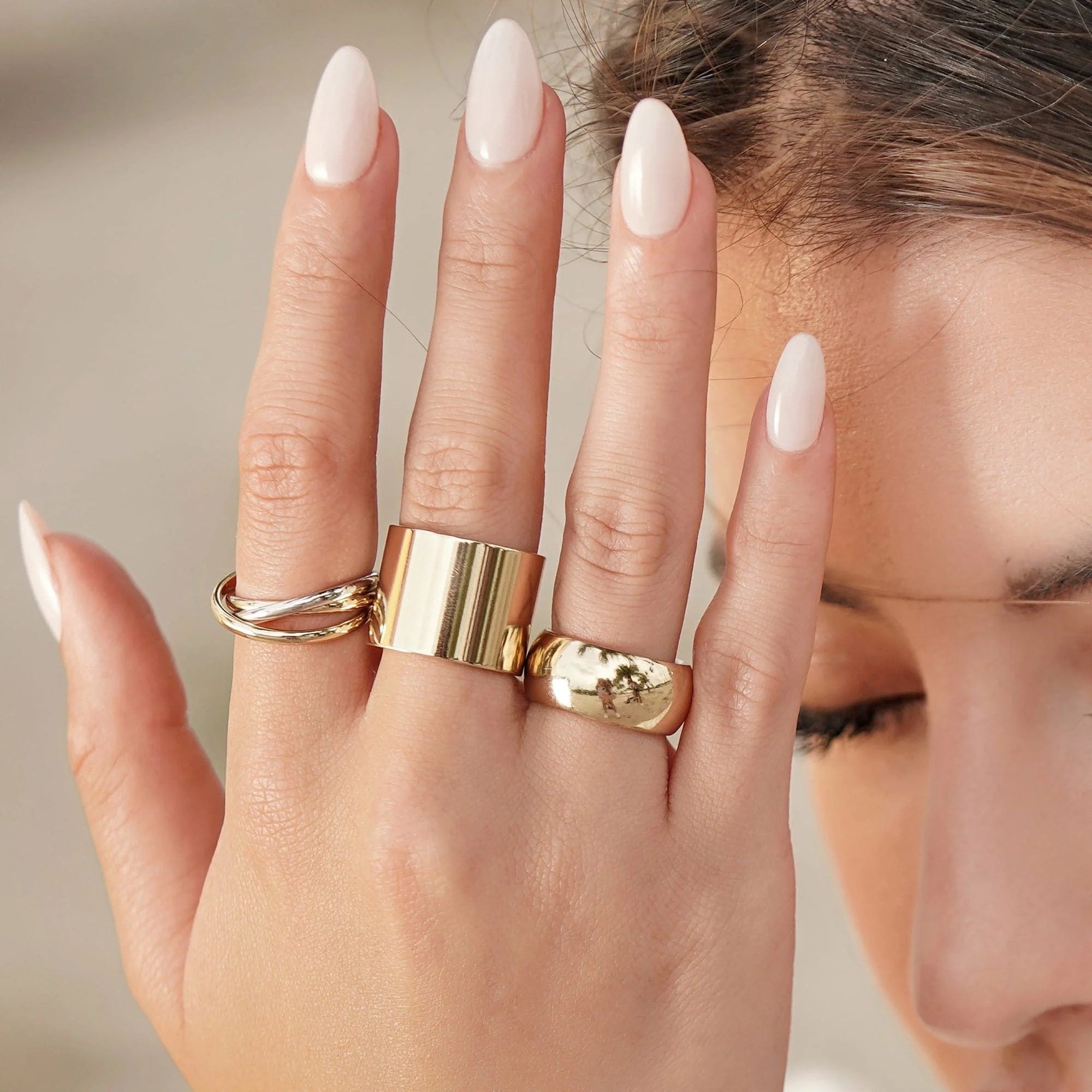 Hand with Gold Rings wearing a two toned triple domed roll ring for elegant jewelry style