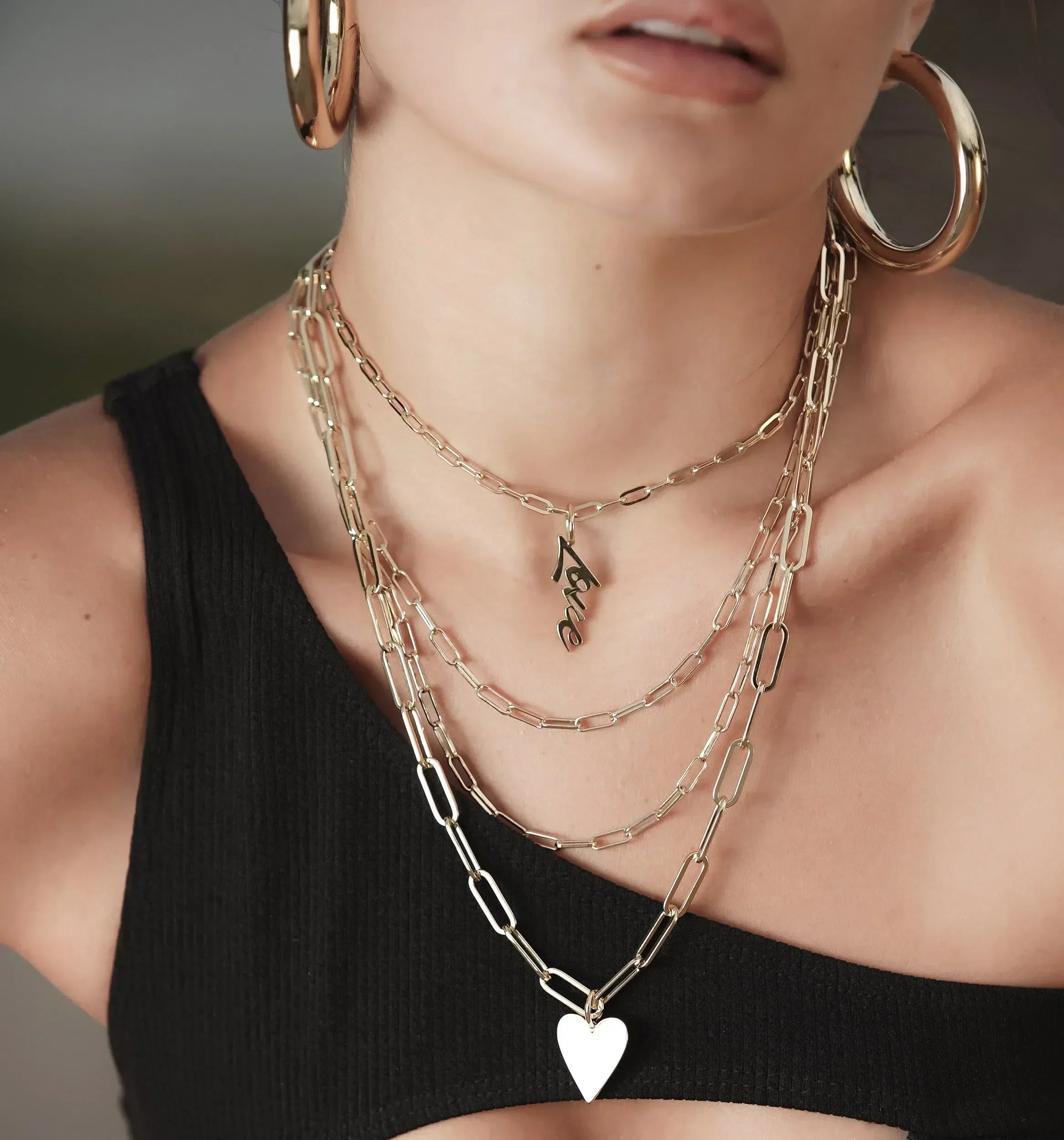 Gold layered necklace set featuring stylish pendants and elongated link designs.