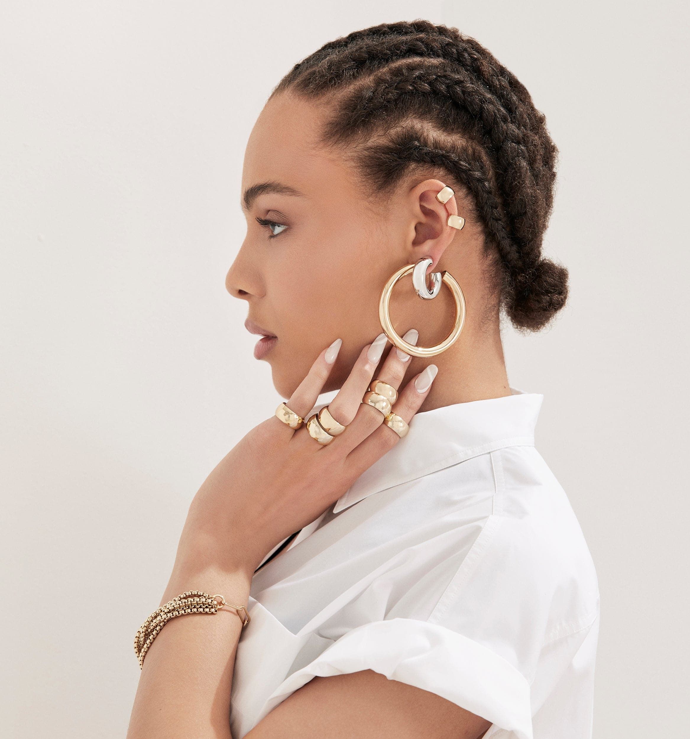 Woman wearing a stunning 9.5mm Domed Ring with shiny gold jewelry