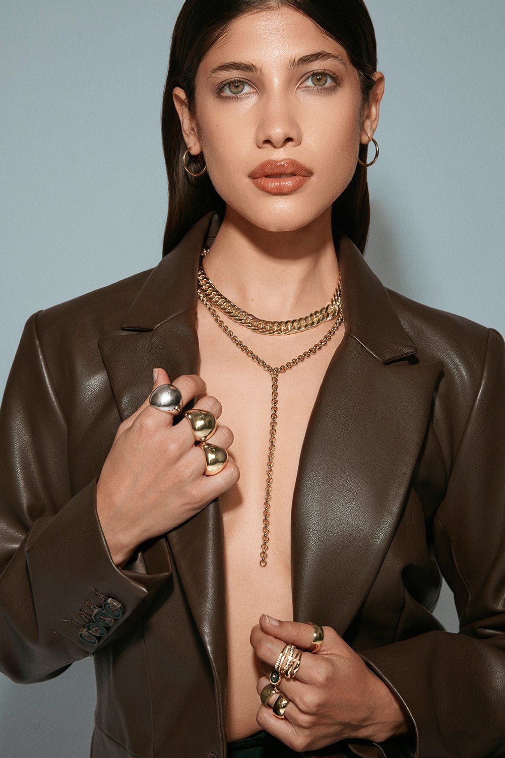 Woman wearing Arya Necklace and a brown leather jacket showcasing stylish jewelry
