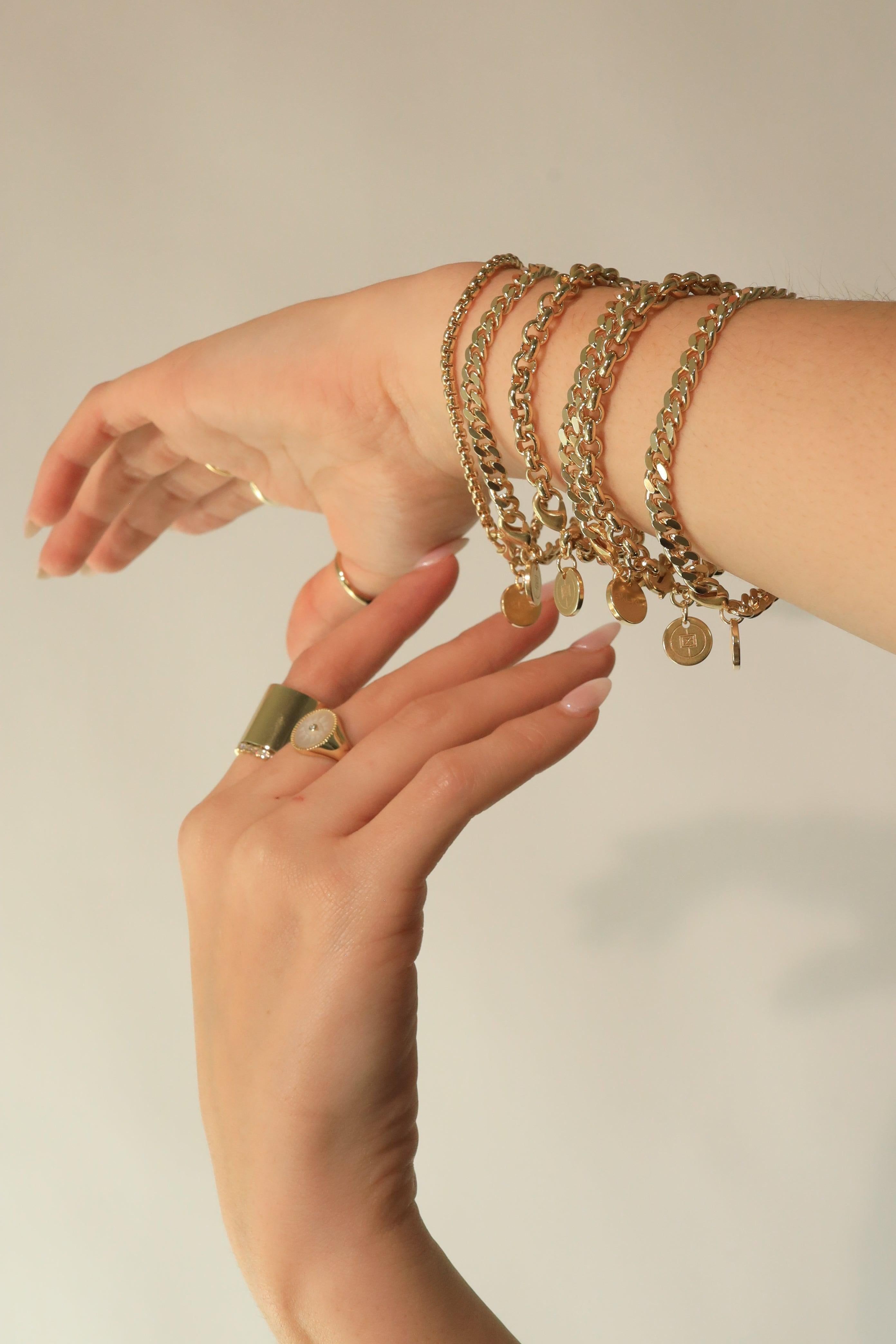 Gold chain bracelets and rings featured in the Micro Link Curb Chain Bracelet product