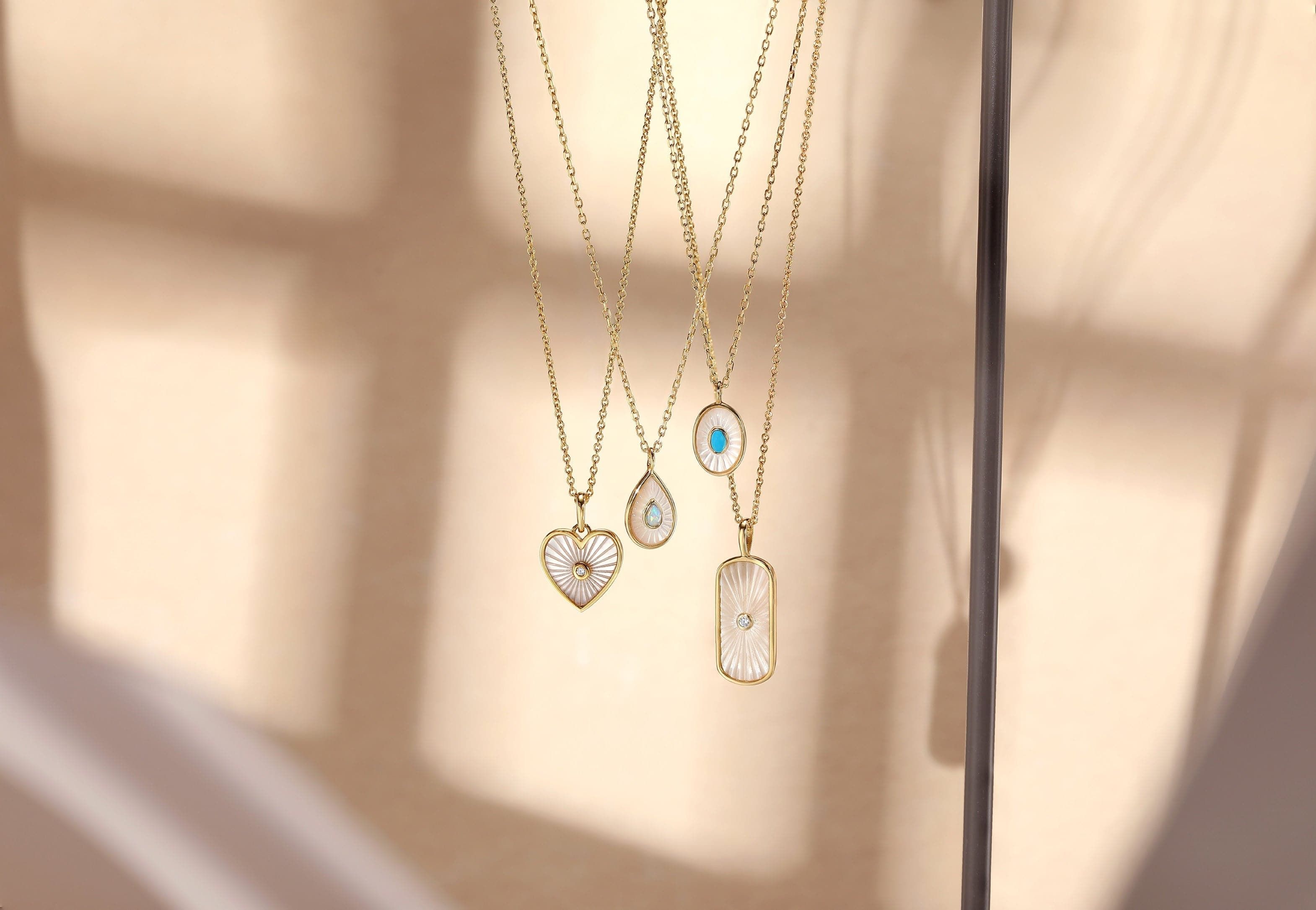 Gold necklaces with decorative oval Mop pendants and turquoise stones for a chic look