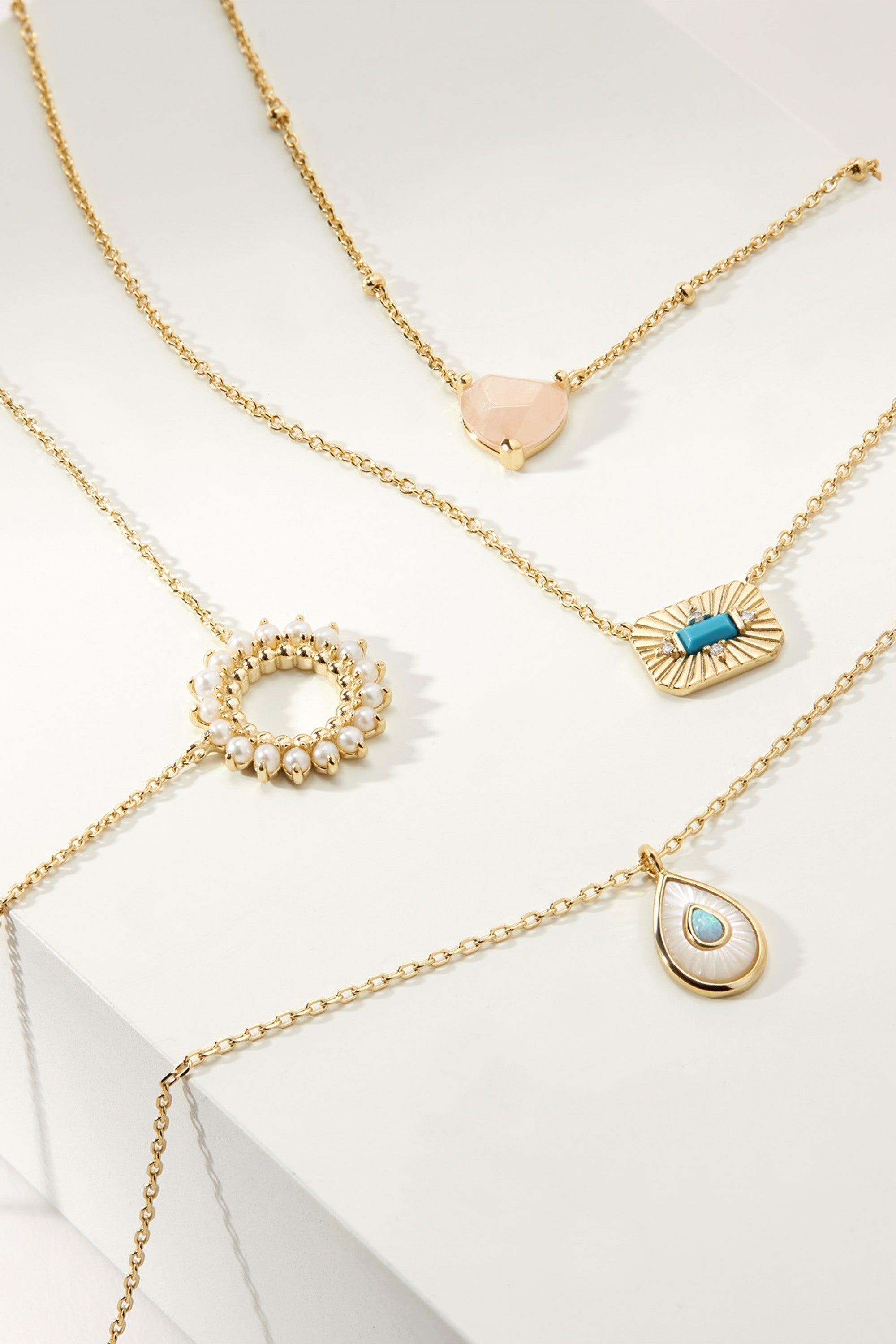 Gold necklaces with various pendants, featuring a Pear Shaped Mop Pendant with Opal