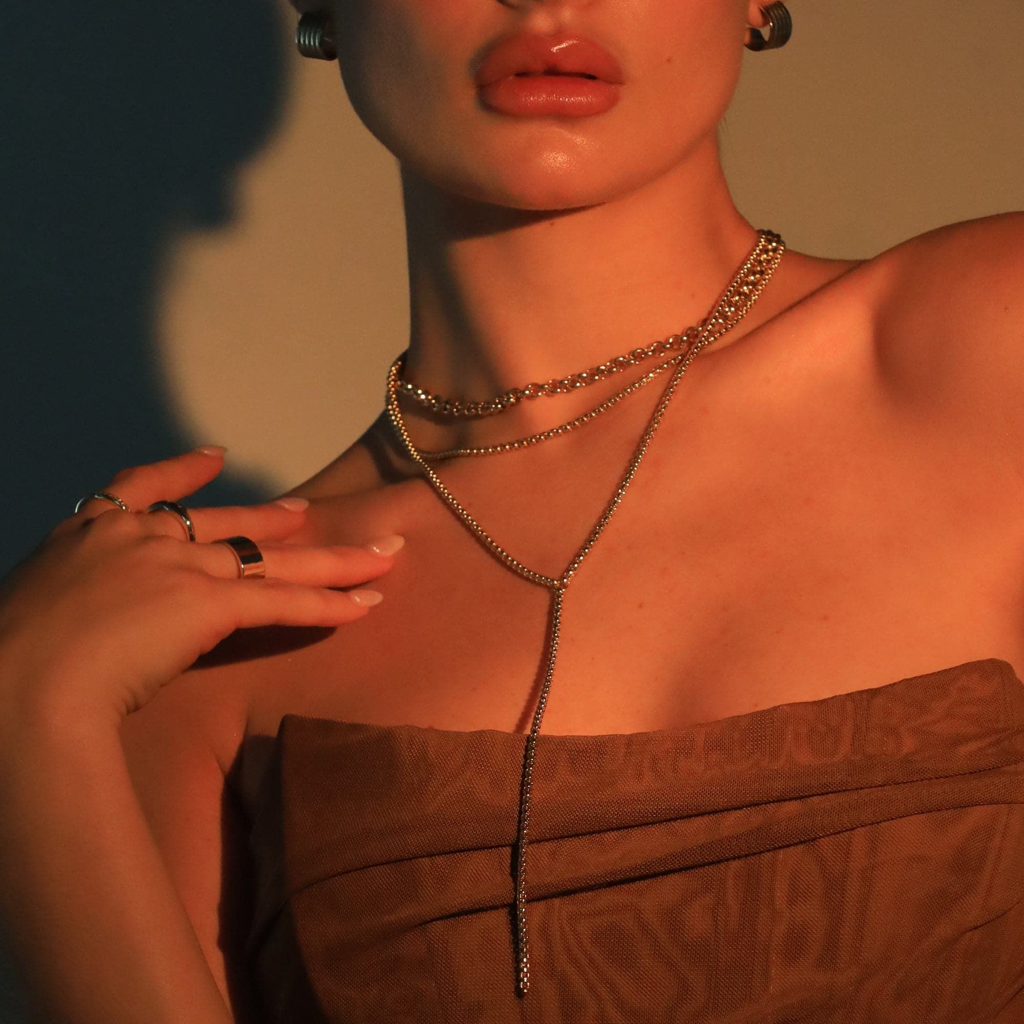 Woman wearing layered gold necklaces featuring the Thin Luciana Box Chain Lariat