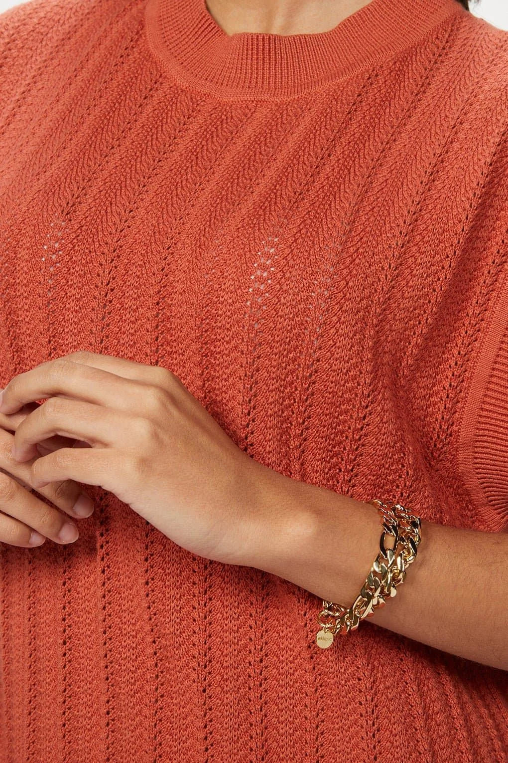 Rust-colored knit top with Axel Bracelet featuring recycled brass figaro chain accessory
