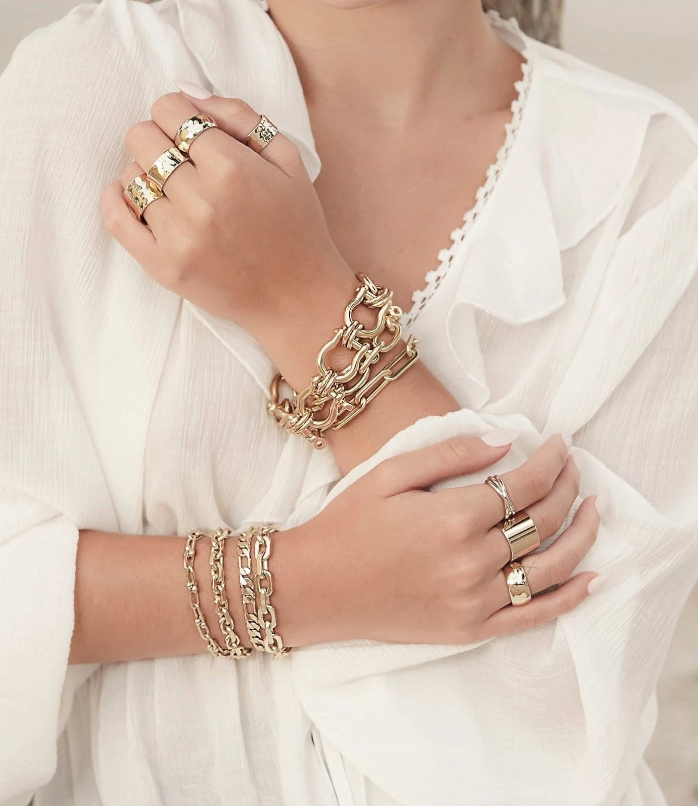 Woman’s hands with gold baby Axel bracelet featuring figaro chain and lobster clasp