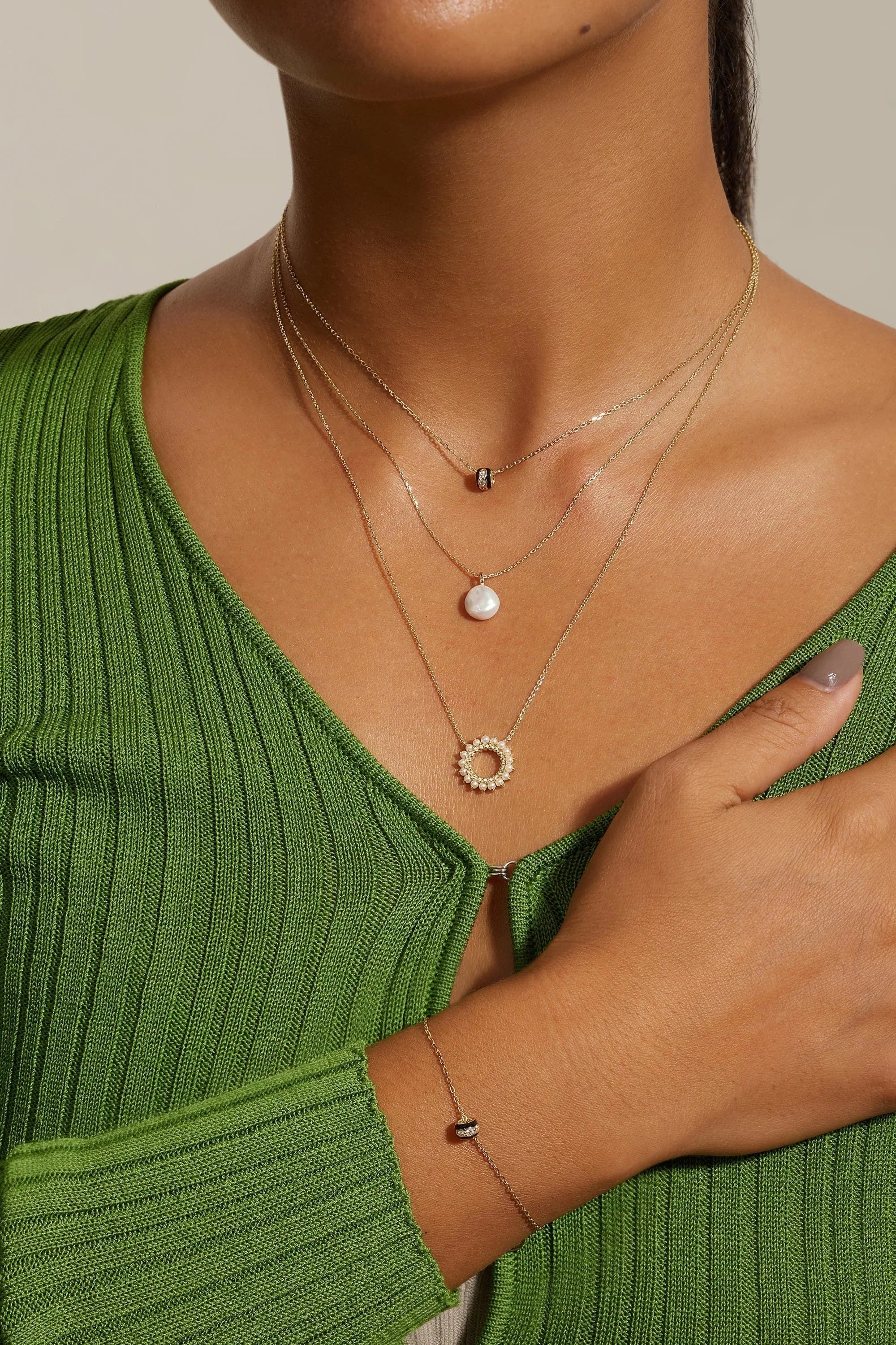 Woman wearing layered 14k gold vermeil necklaces and matching bracelet showcasing vermeil necklace length