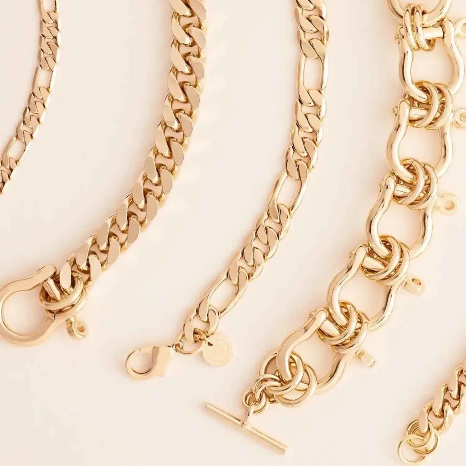 Gold chain bracelets on a light beige background