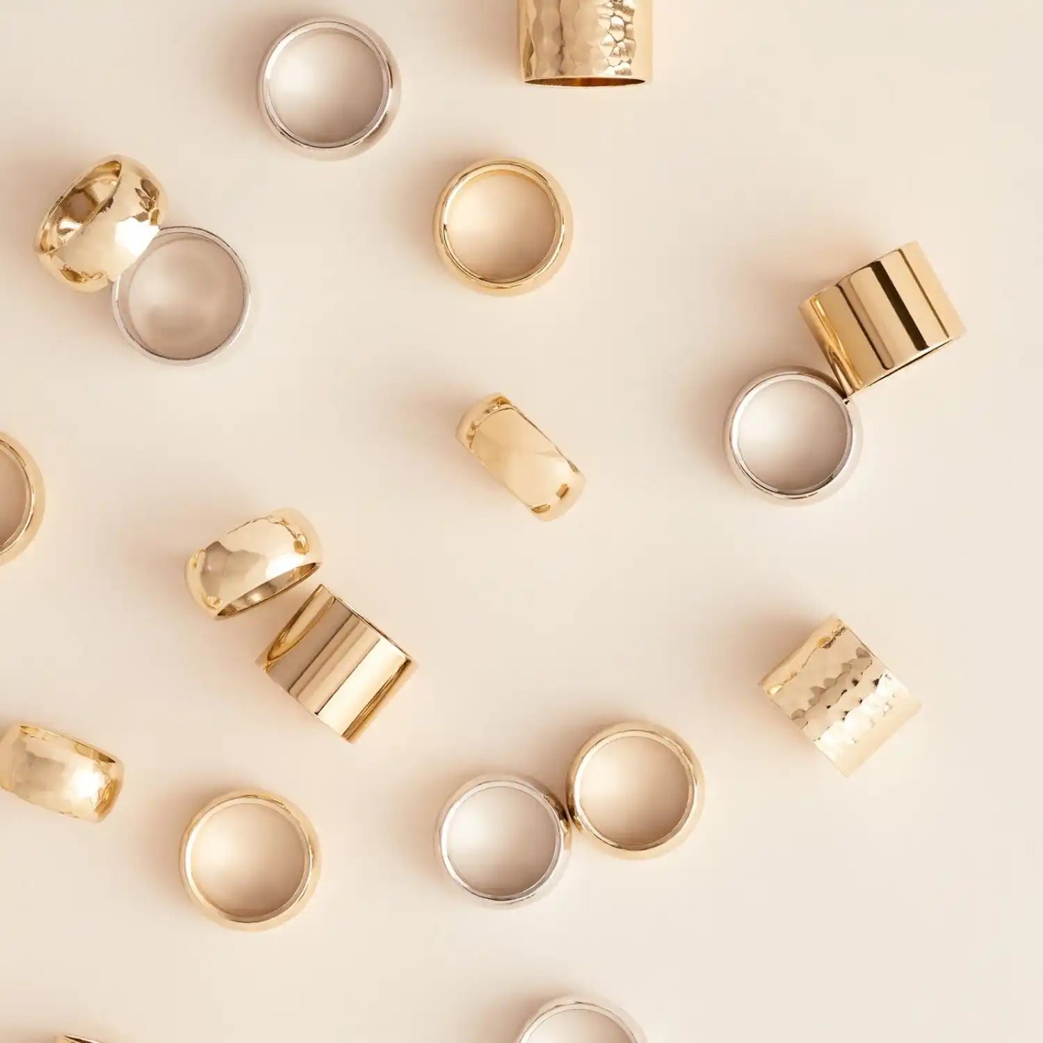 A collection of gold and silver-colored metal rings in various widths and textures.