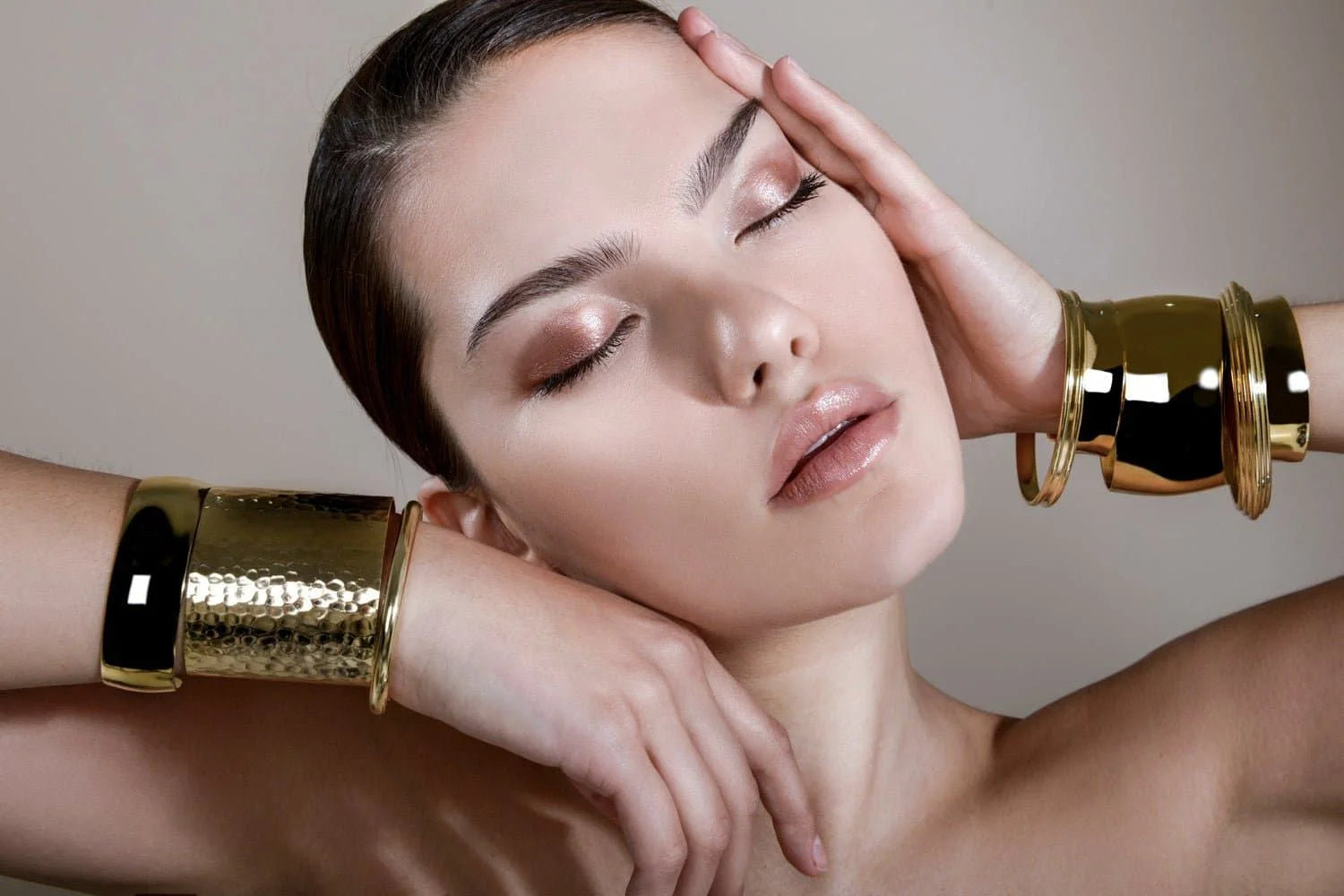 Woman wearing stylish 14k gold ecoat double domed wide bangle bracelets