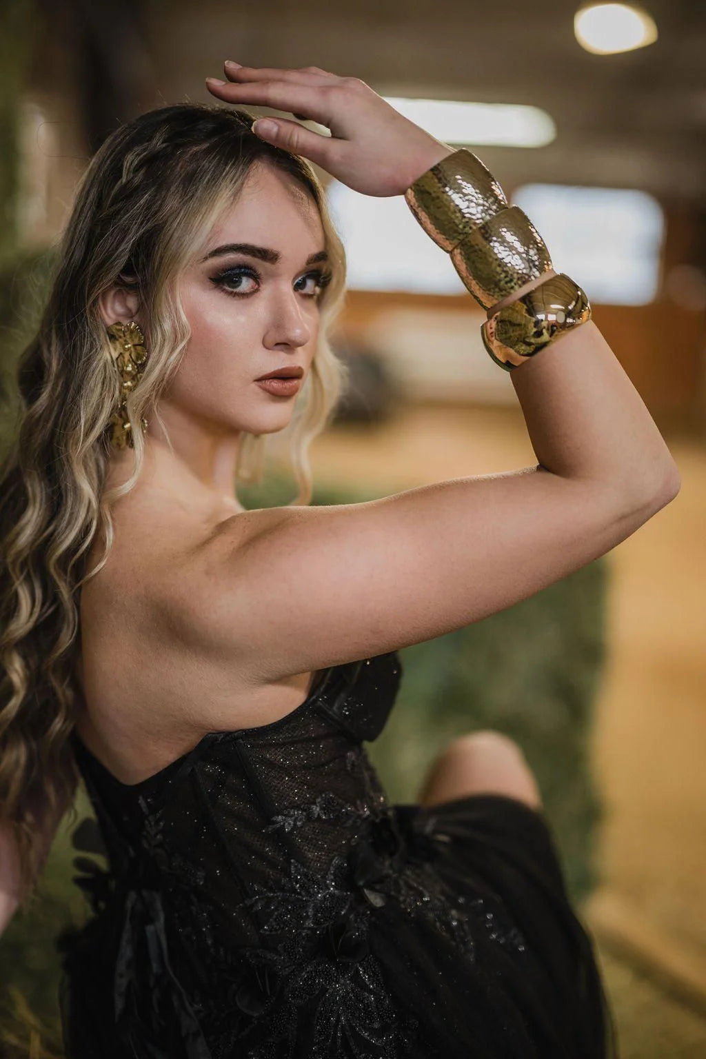 Woman’s gold cuff bracelet shown on a large domed bangle made from recycled brass