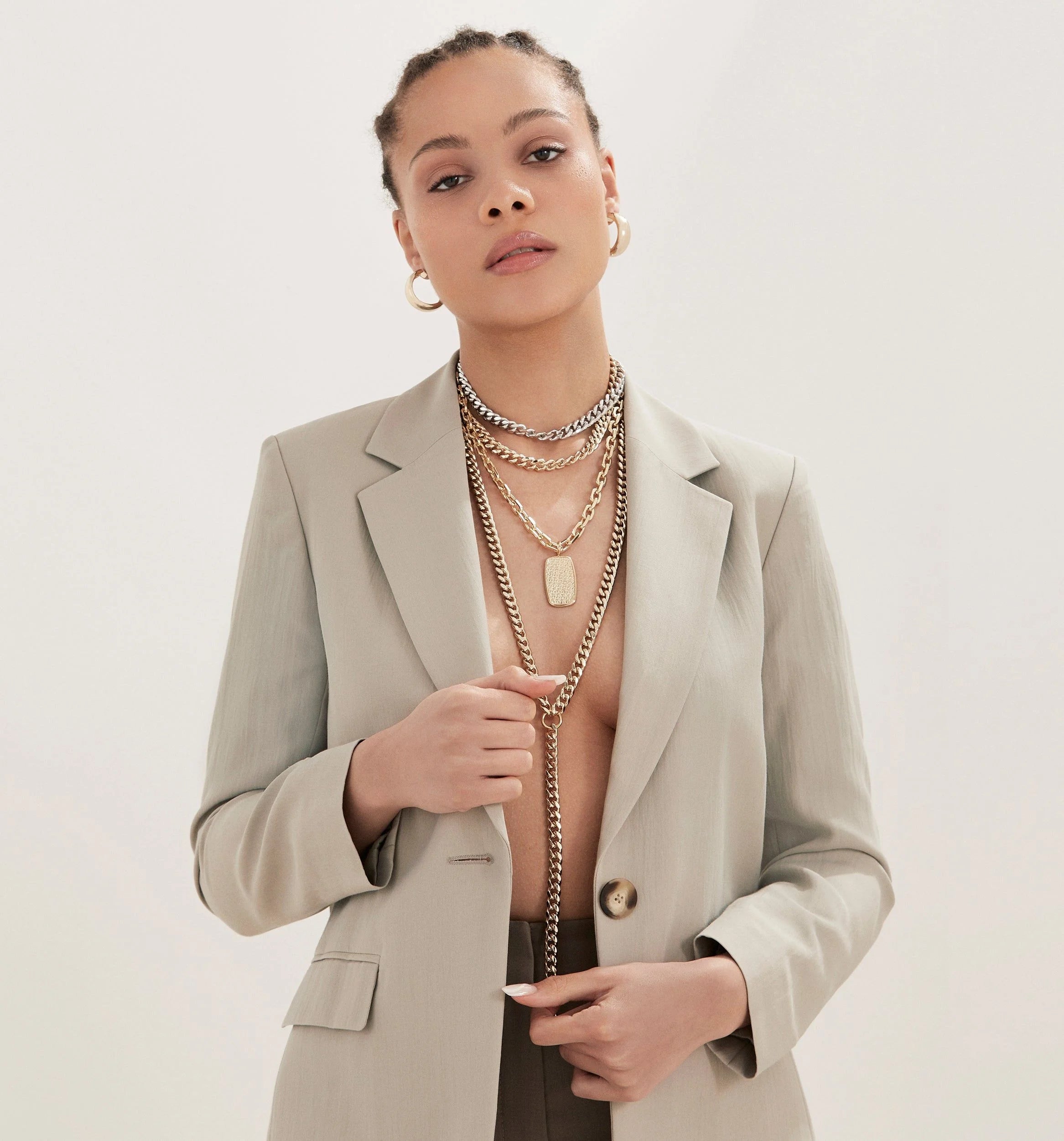 Woman wearing a blazer and layered necklaces featuring the Lenox Pendant 14k gold barrel shaped pendant