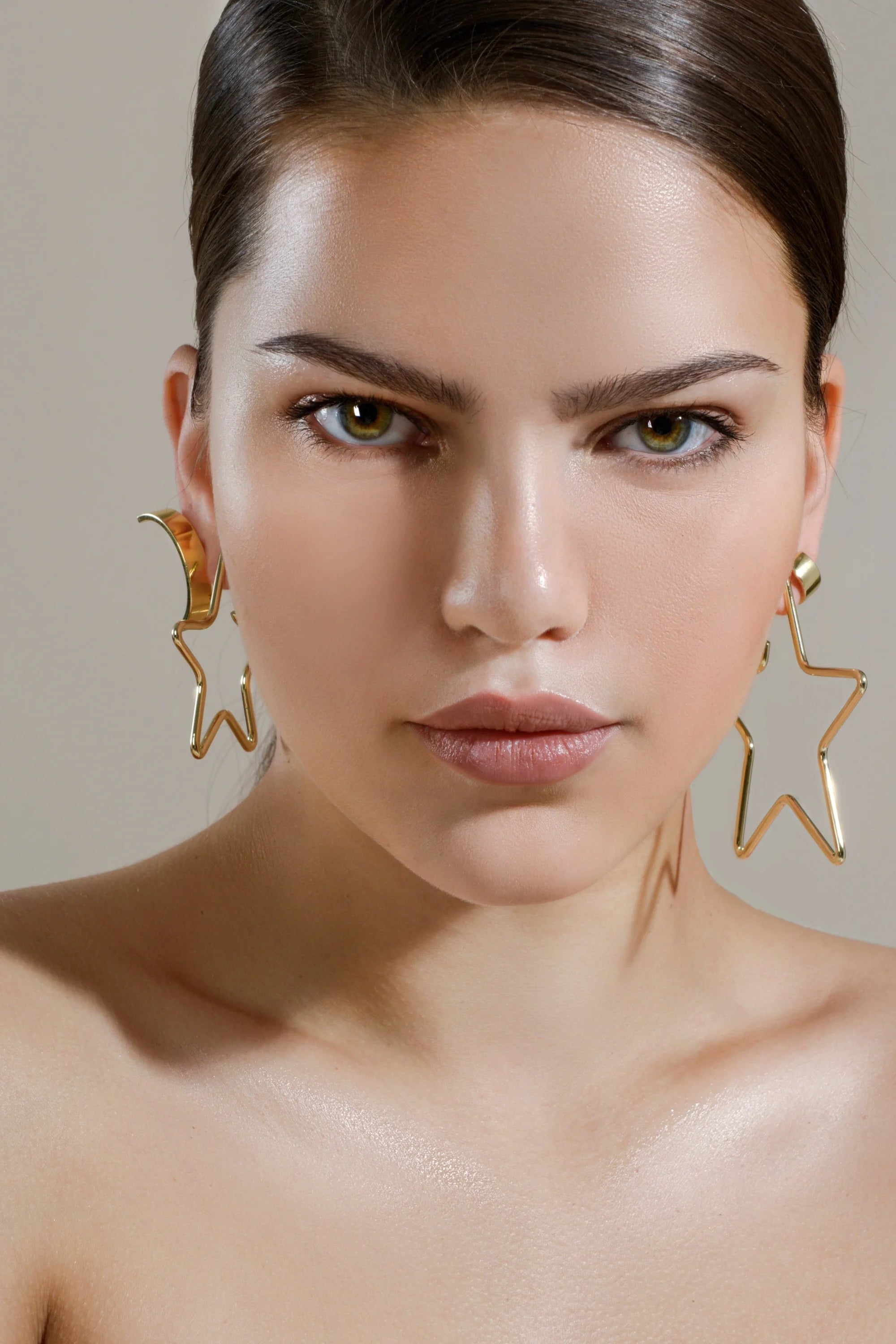 Woman wearing medium full star earrings in 14k yellow gold rhodium brass earring jewelry