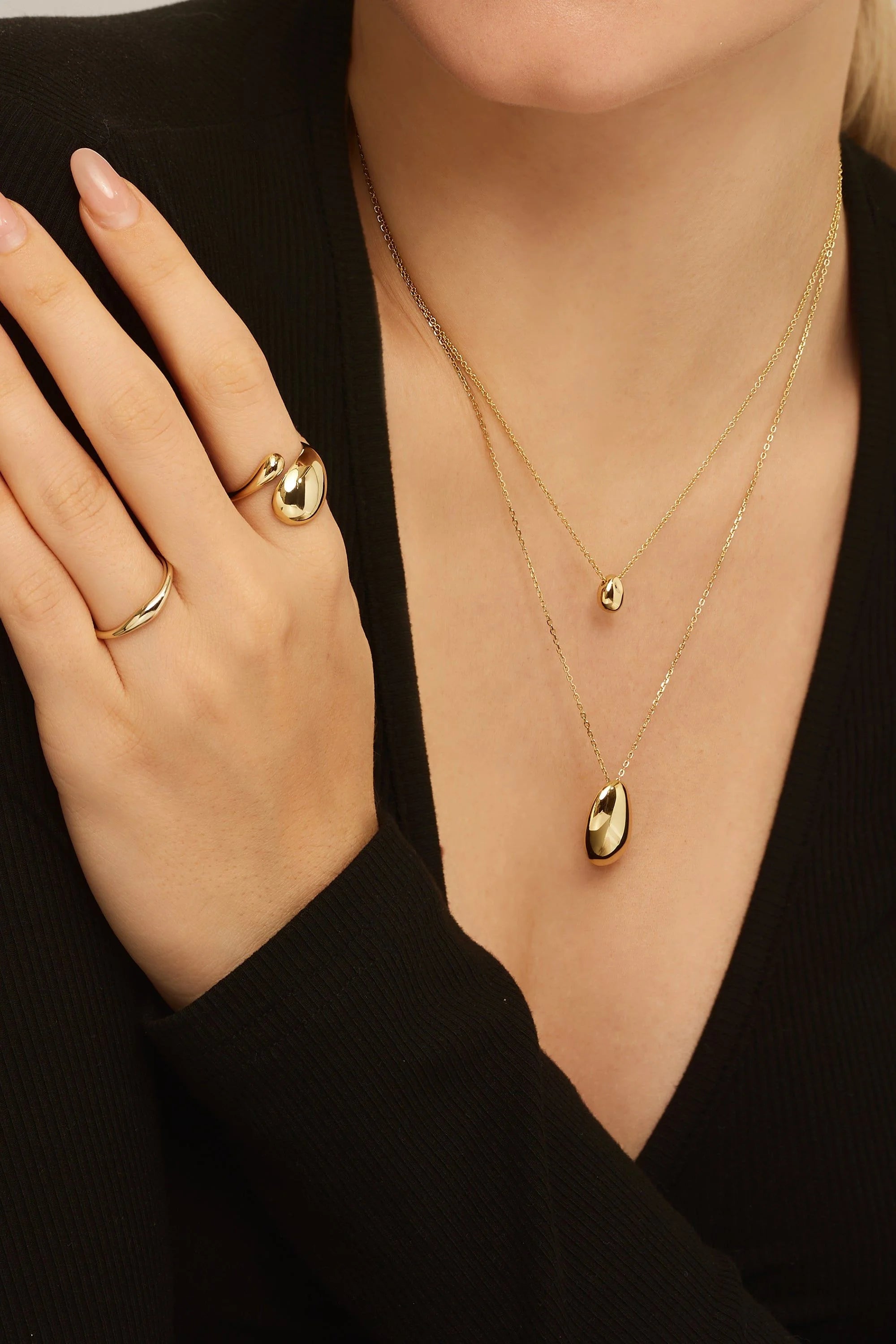 Gold jewelry set featuring the Micro Harmony Pebble Pendant Necklace and pebble pendant necklace