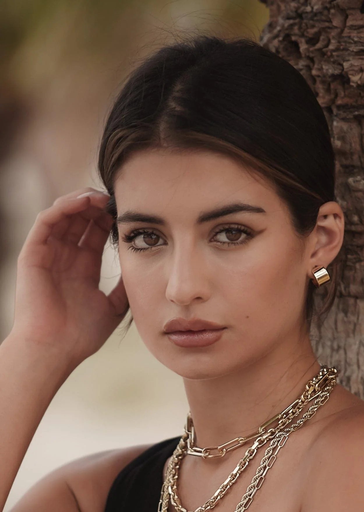 Woman wearing Mini .5 Skylar Hoops made of 14k gold rhodium and recycled brass hoops