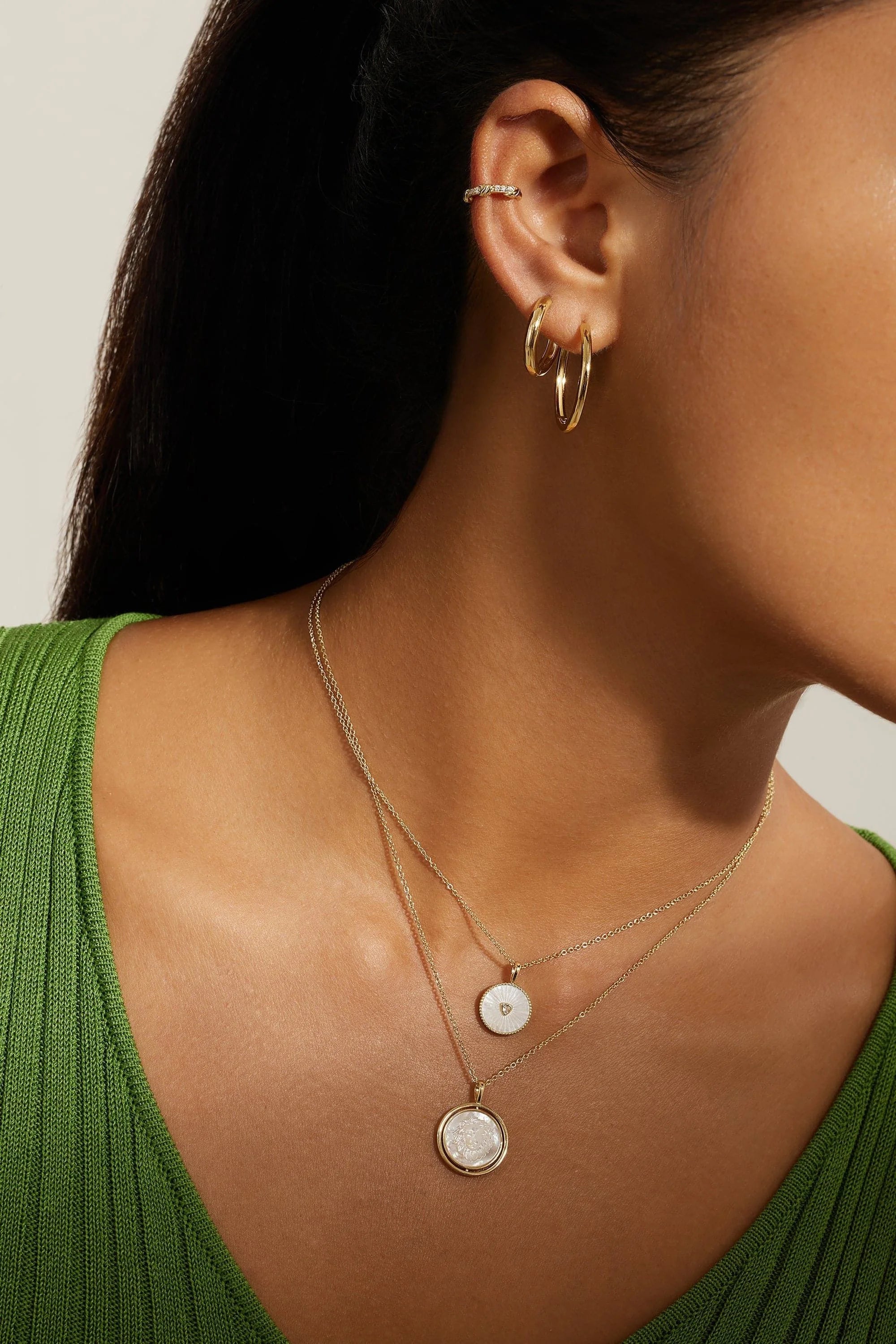 Woman wearing 14k gold plated mini huggie hoop earrings for elegant jewelry style