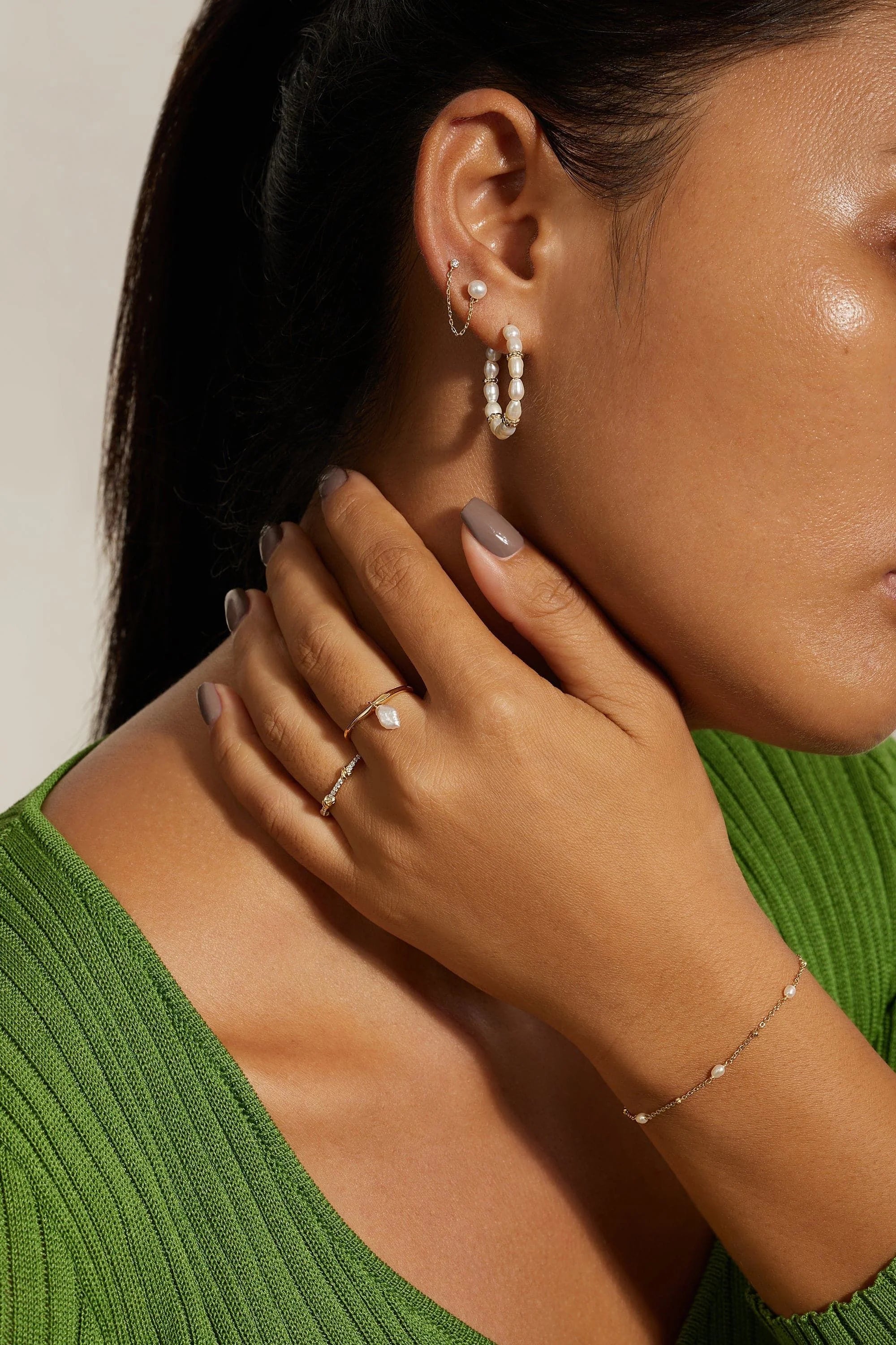 Woman wearing Pearl Beaded Huggie Hoops featuring 14k gold plating and sterling silver finish
