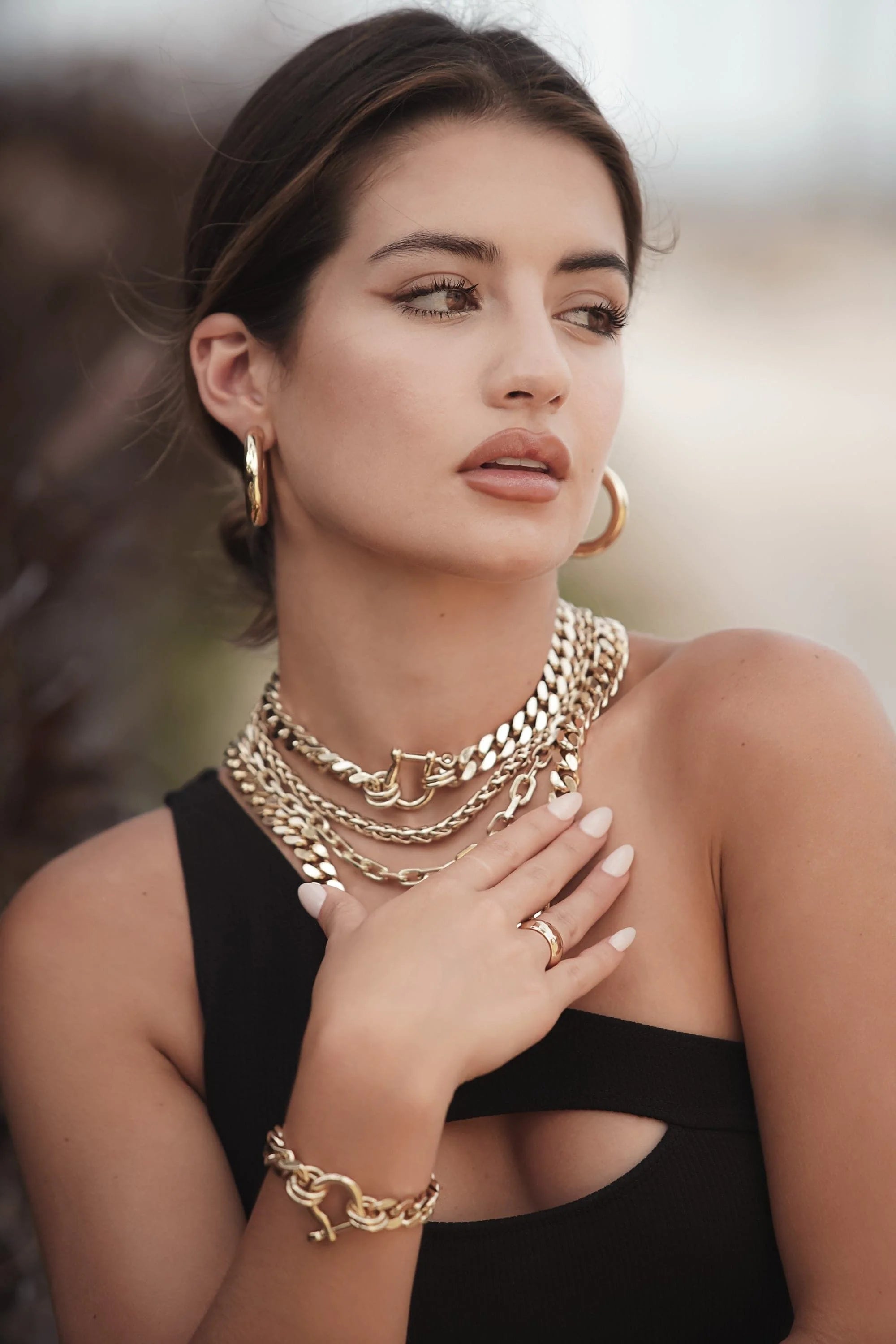 Woman wearing Roxy Bracelet with recycled brass Cuban link and horseshoe clasp