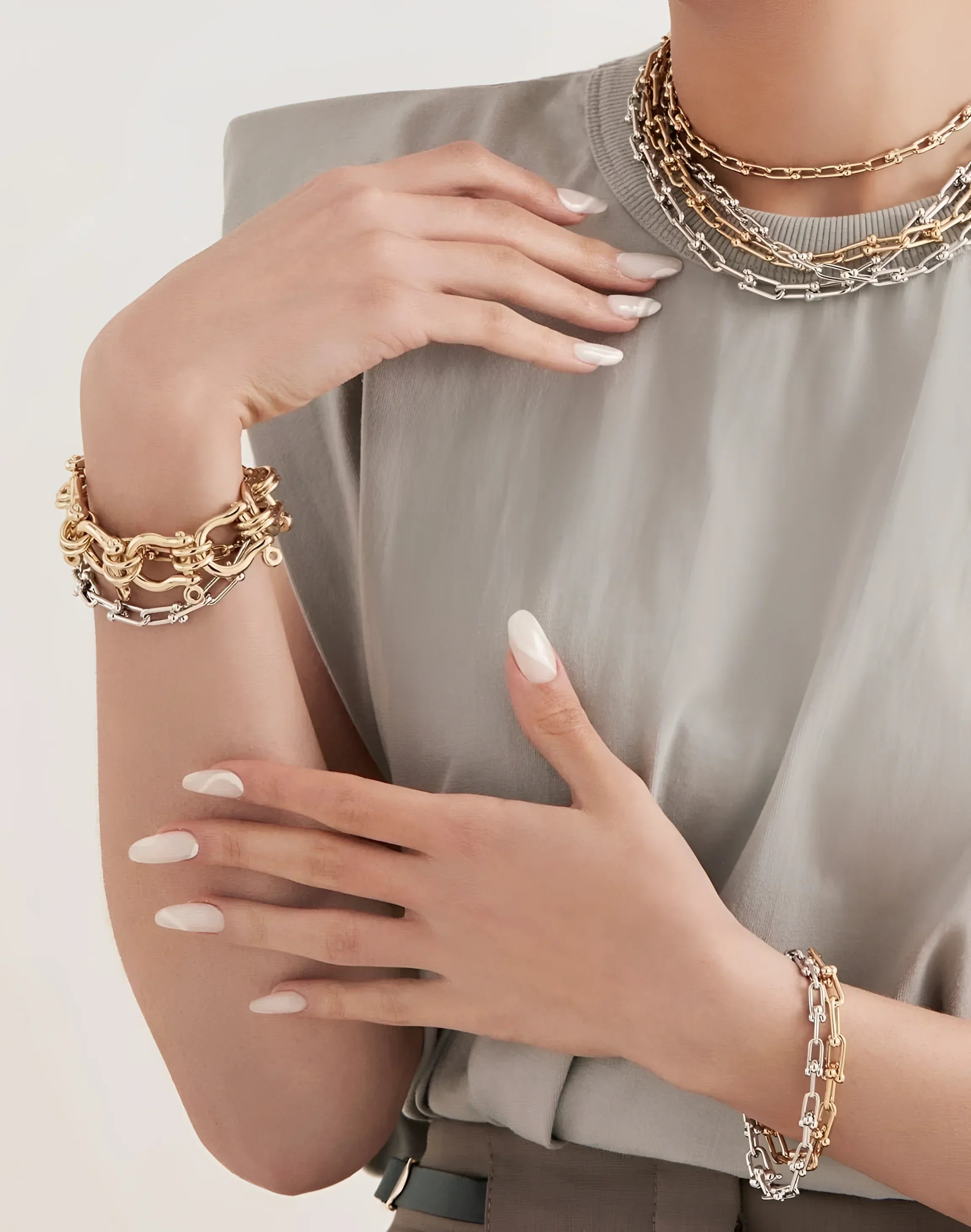 Woman wearing gold and silver jewelry, showcasing the Small Margaux Bracelet with a custom U link in 14k gold