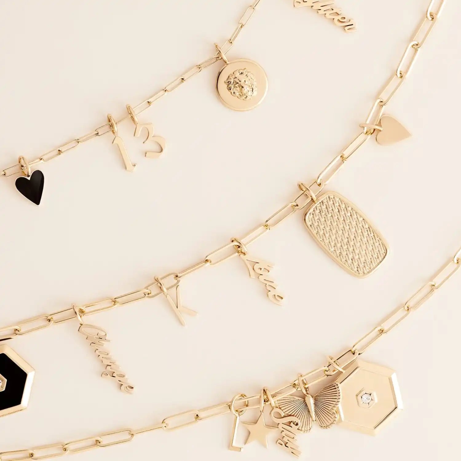 Three gold-toned charm bracelets with various pendants.